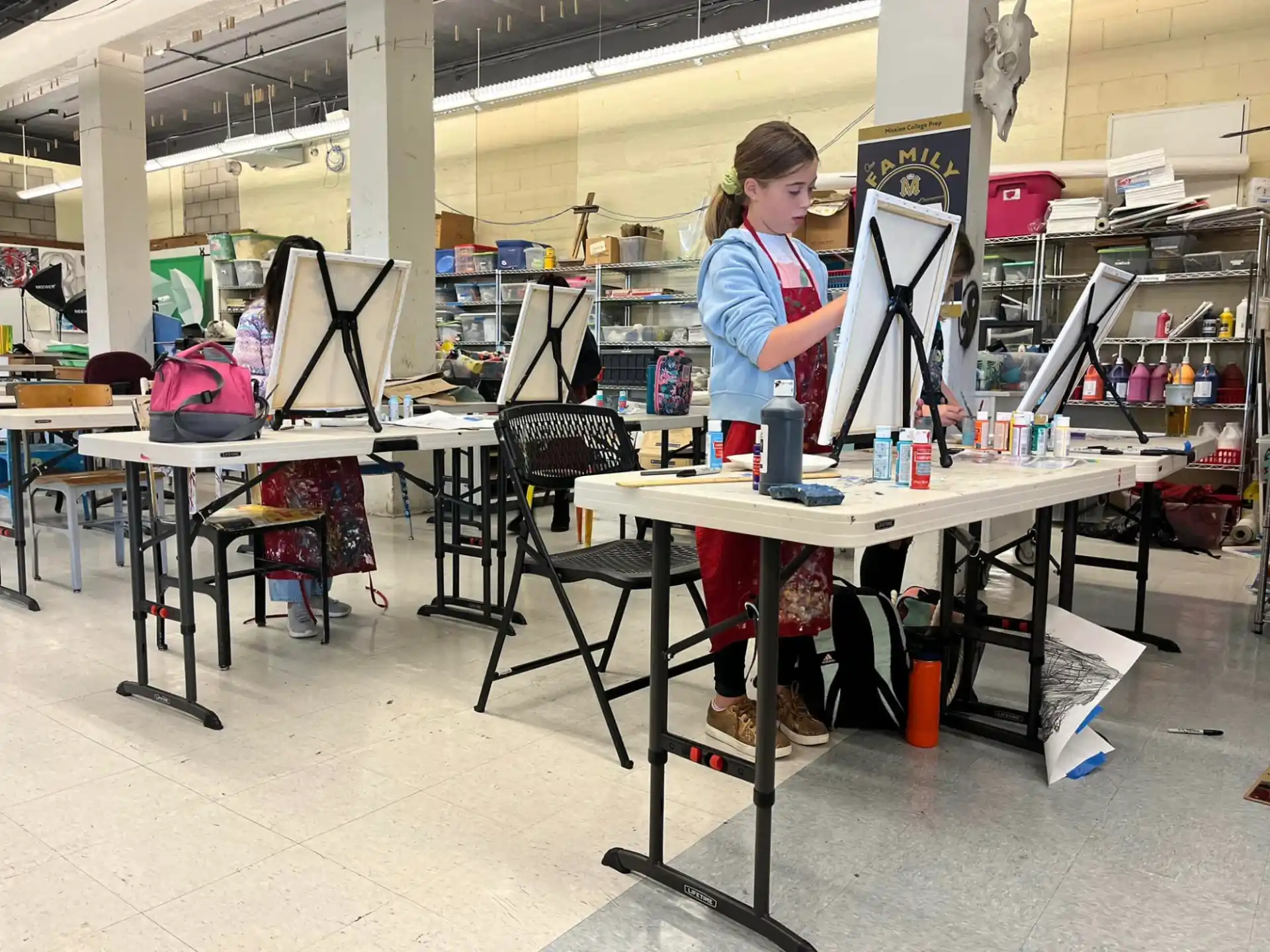a person standing next to a table with a computer and other objects