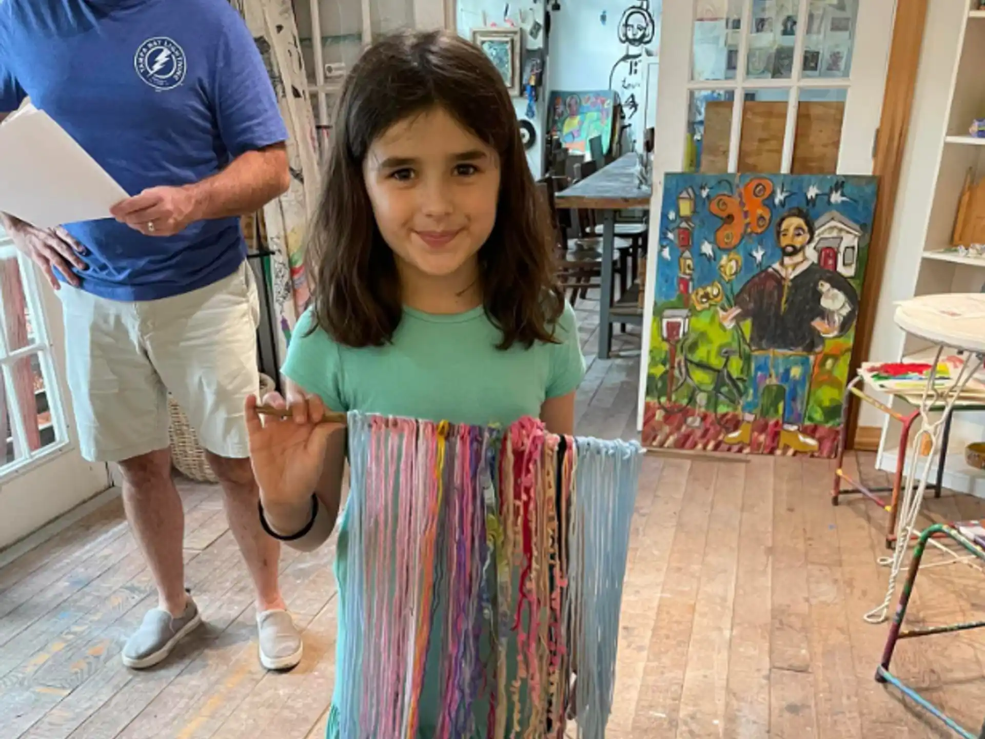 a girl holding a piece of artwork