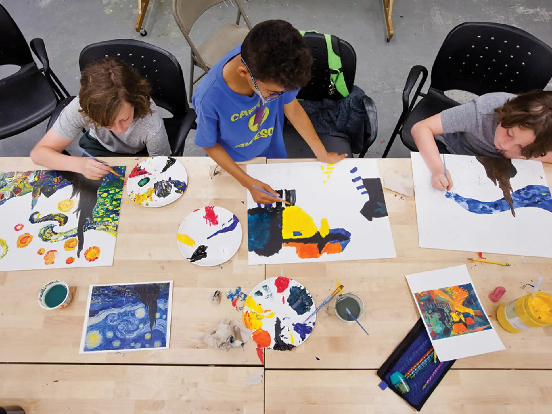 a group of people sitting at a table with drawings on it