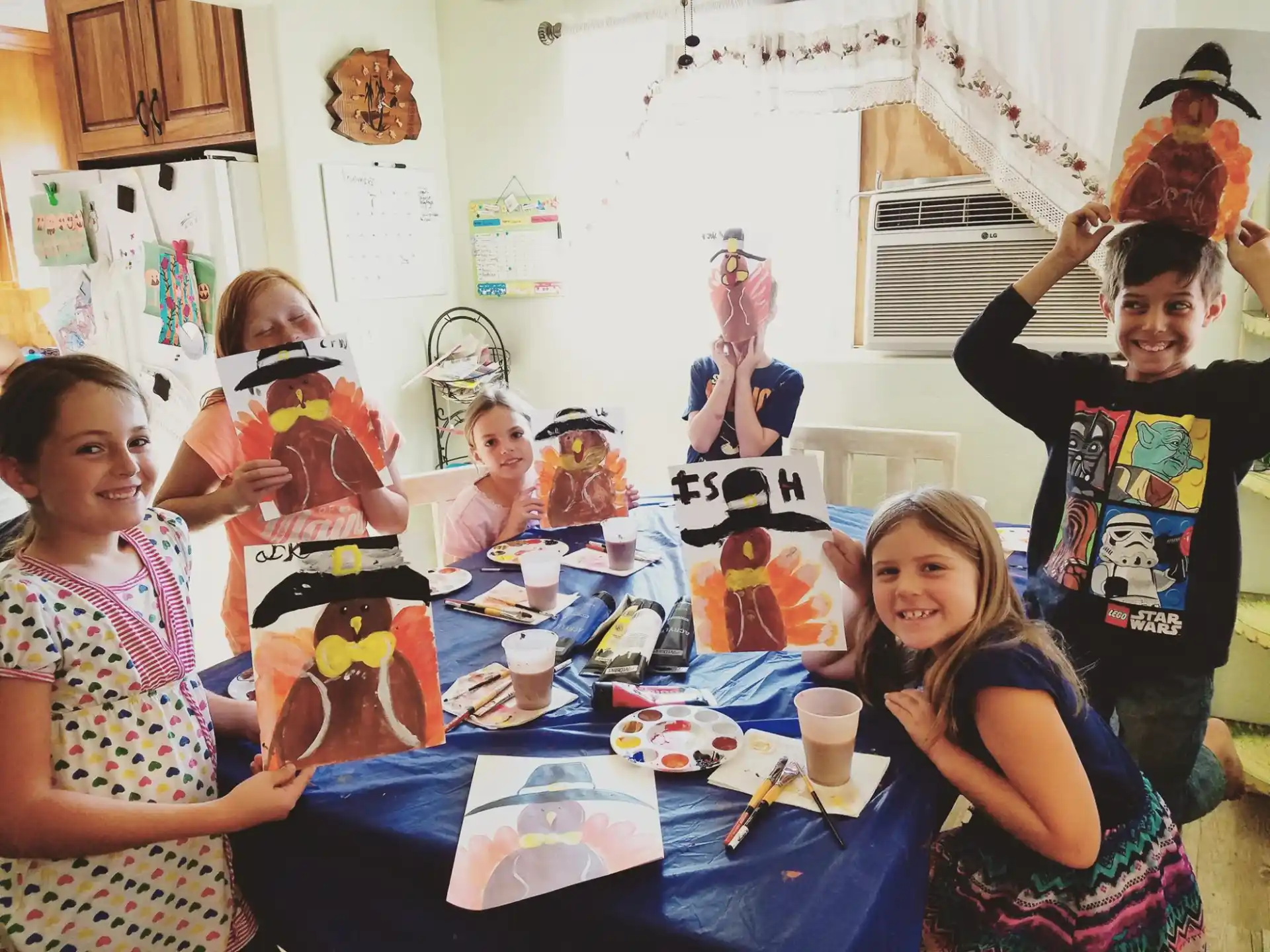 a group of children sitting at a table with toys