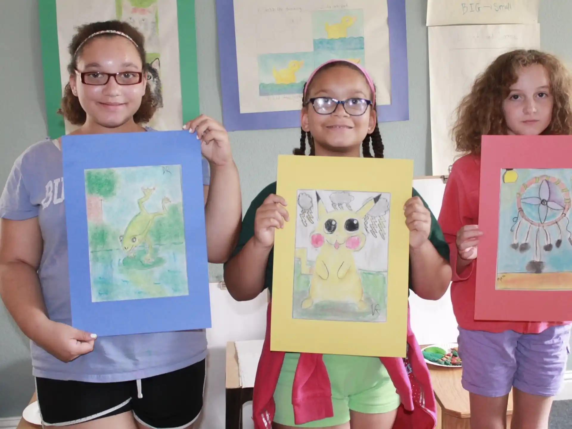 a group of girls holding framed pictures