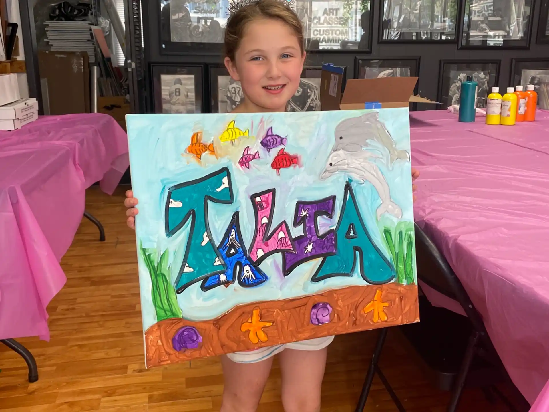 a girl holding a large blue and white box with a crown on it