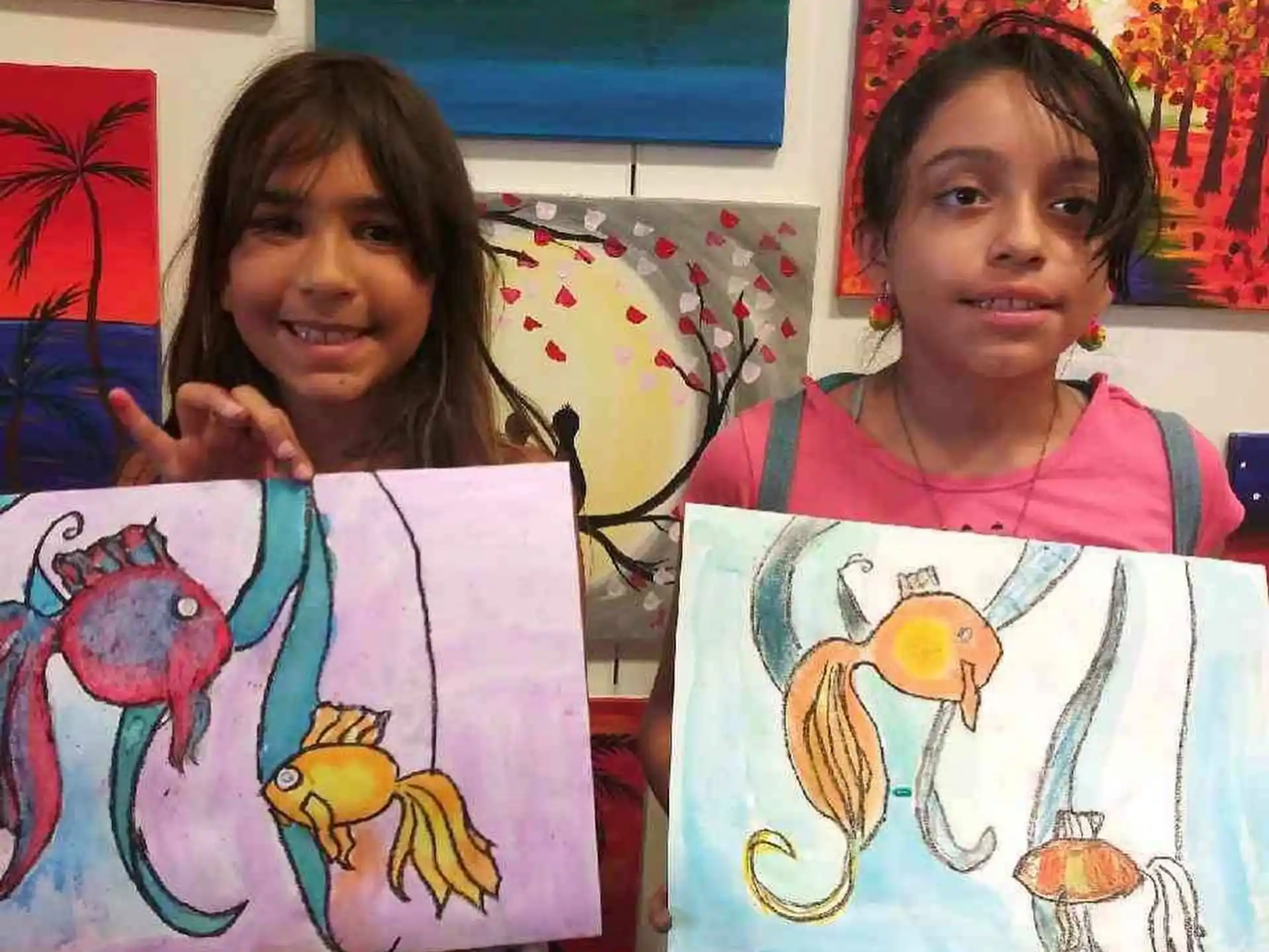 a couple of girls holding a drawing