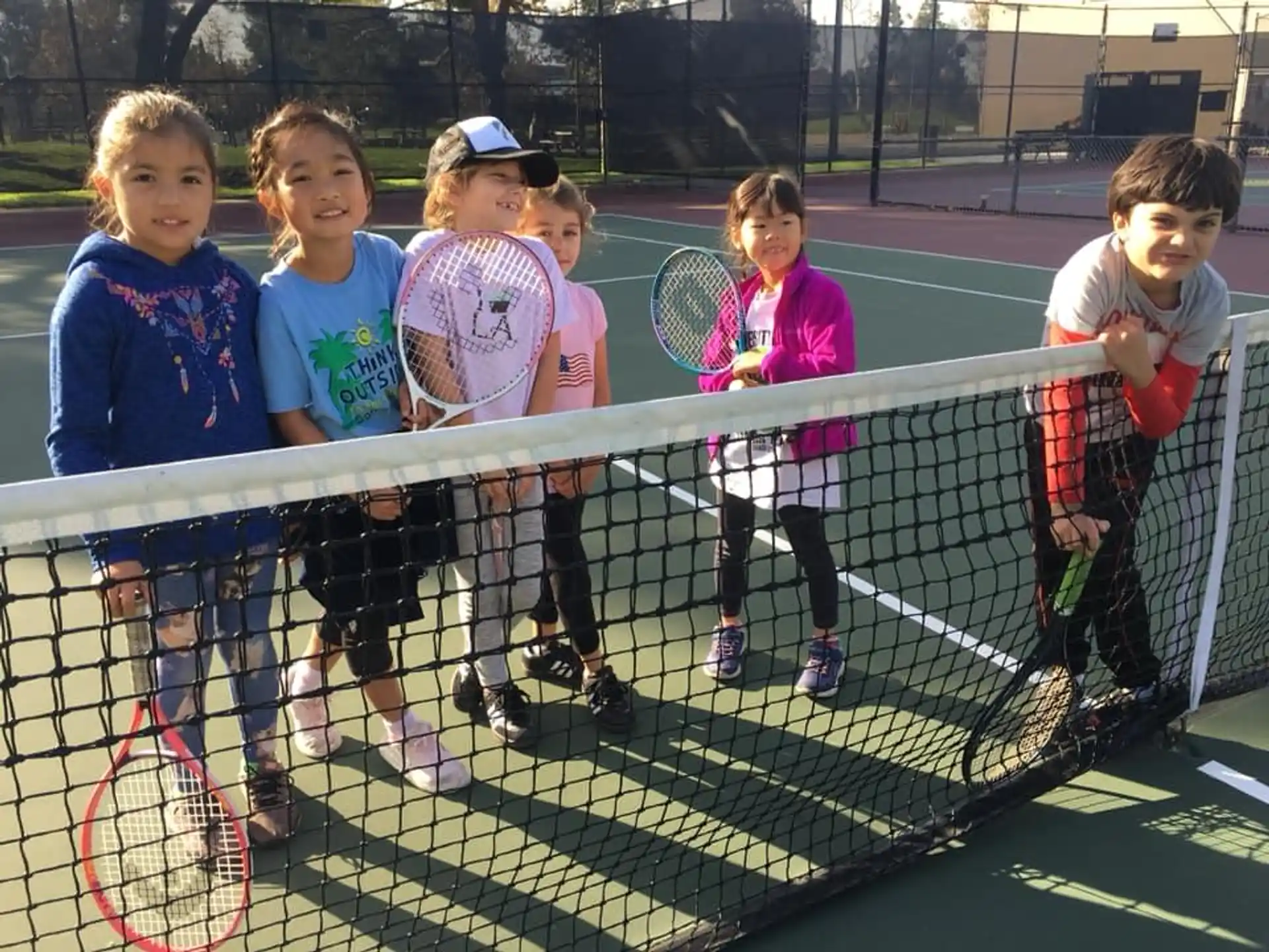 a group of kids holding tennis rackets