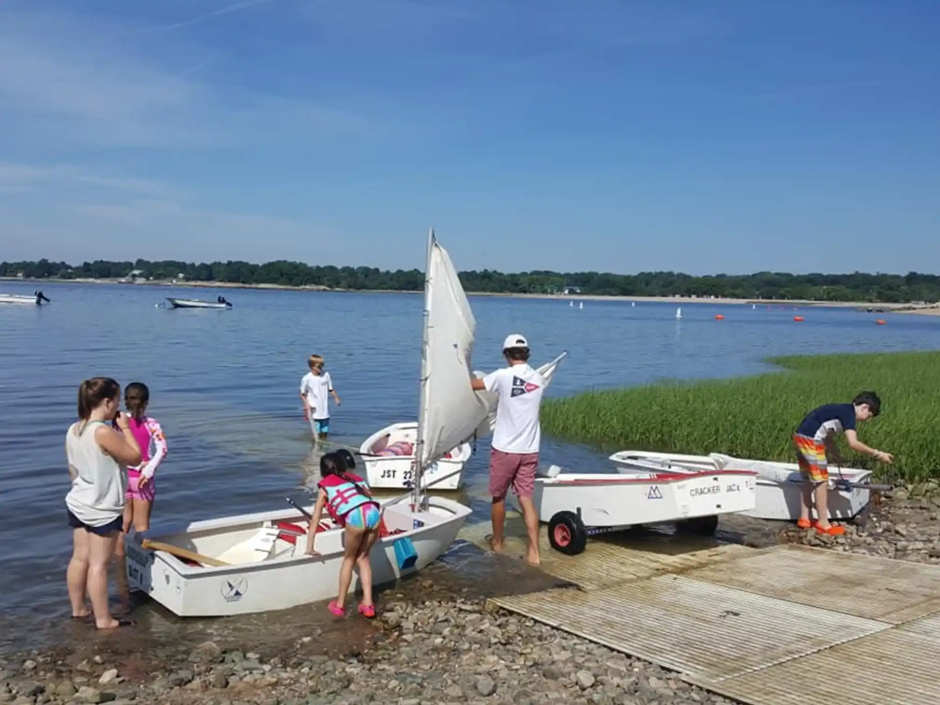 a group of people standing next to a small boat on a dock