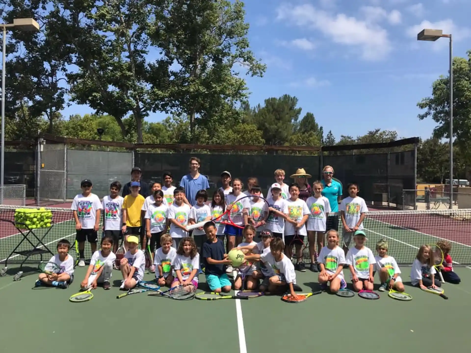 a group of people posing for a photo on a tennis court