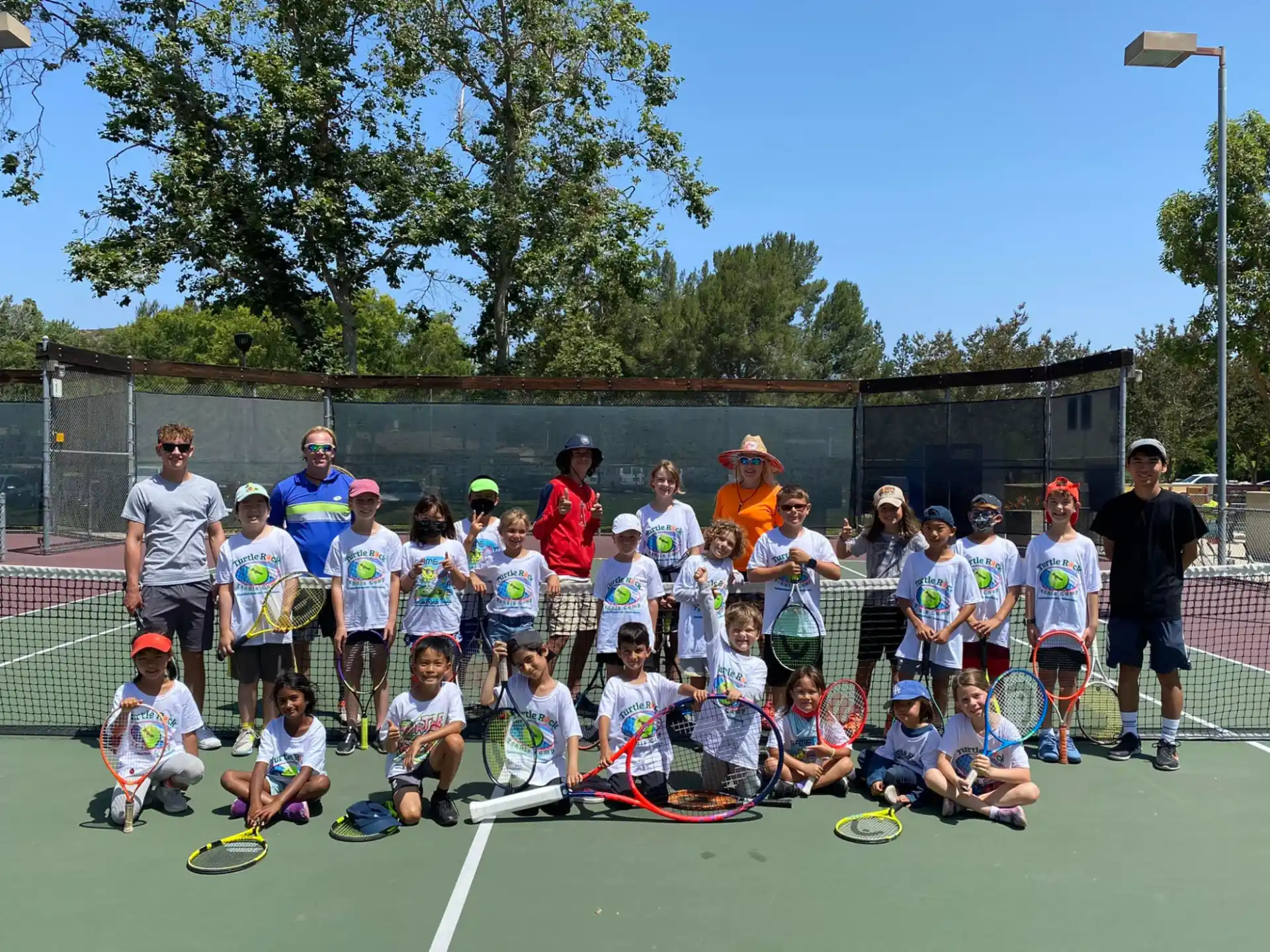 a group of people posing for a photo with tennis rackets