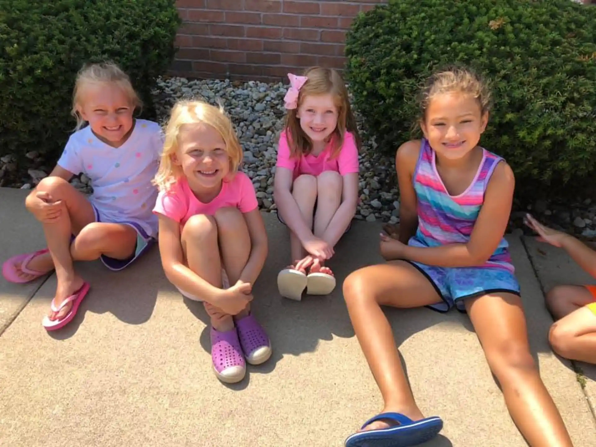 a group of children sitting on the ground outside