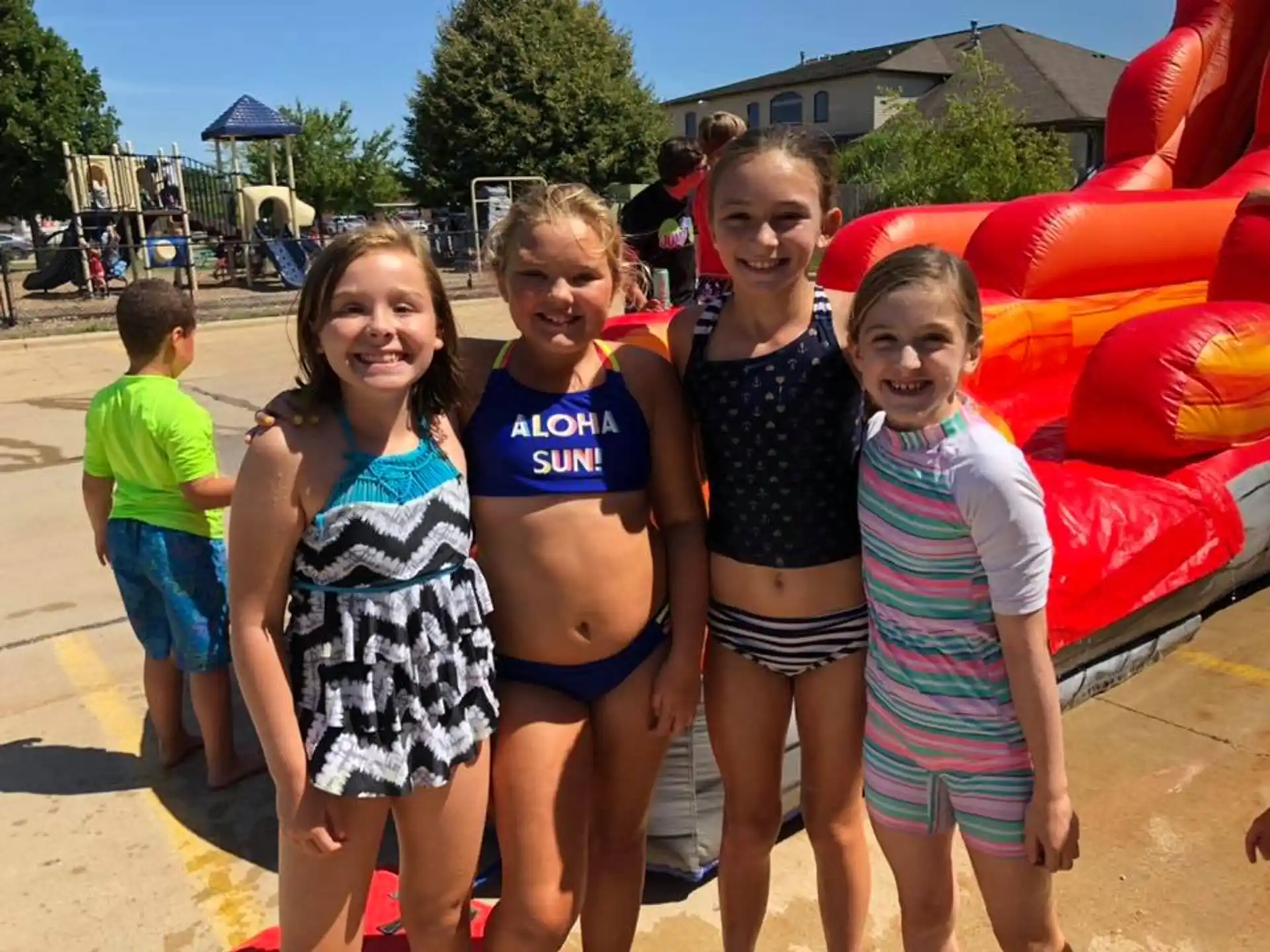 a group of girls posing for a photo in front of a red and yellow playground