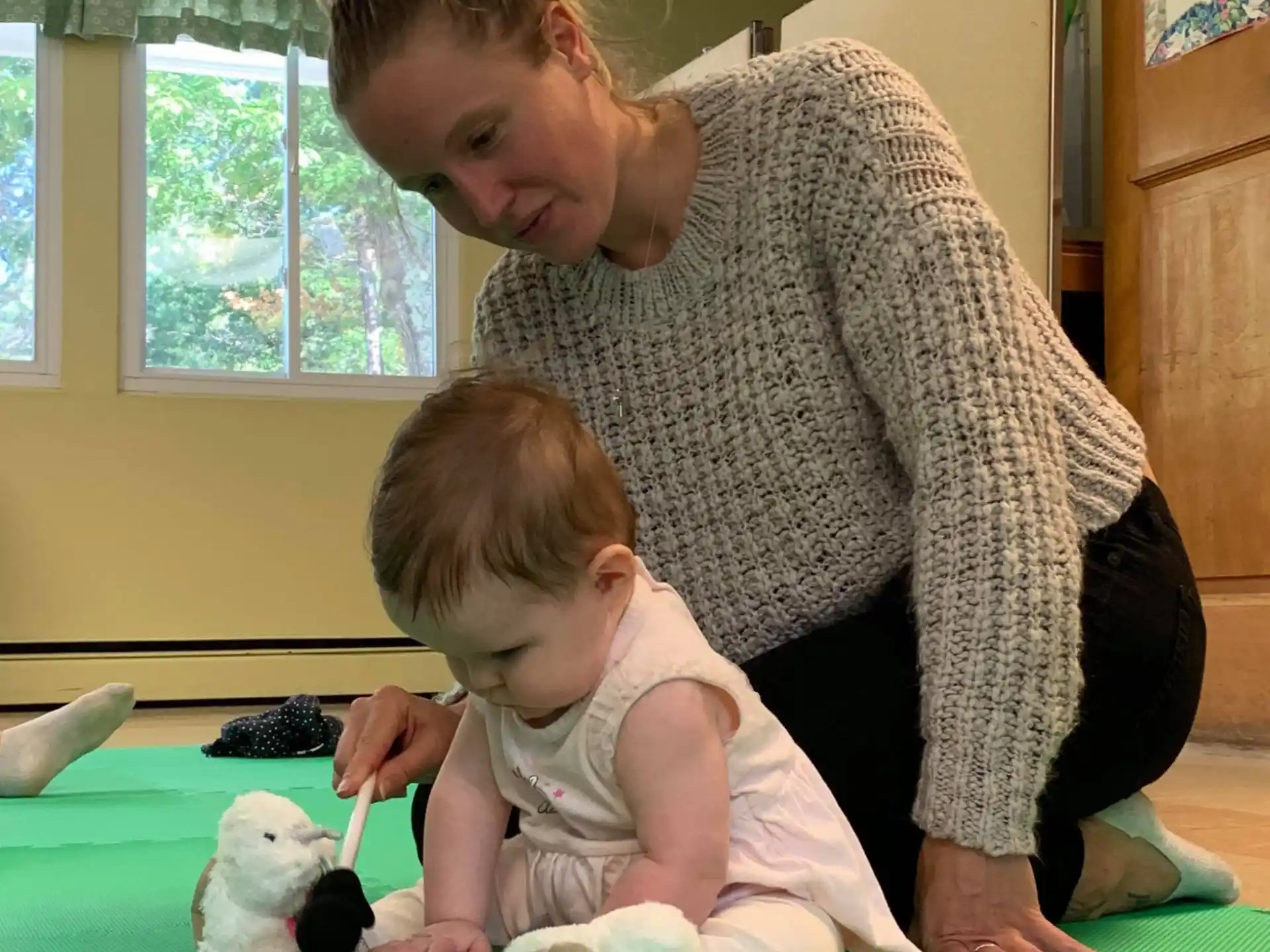 a person and a baby playing with toys
