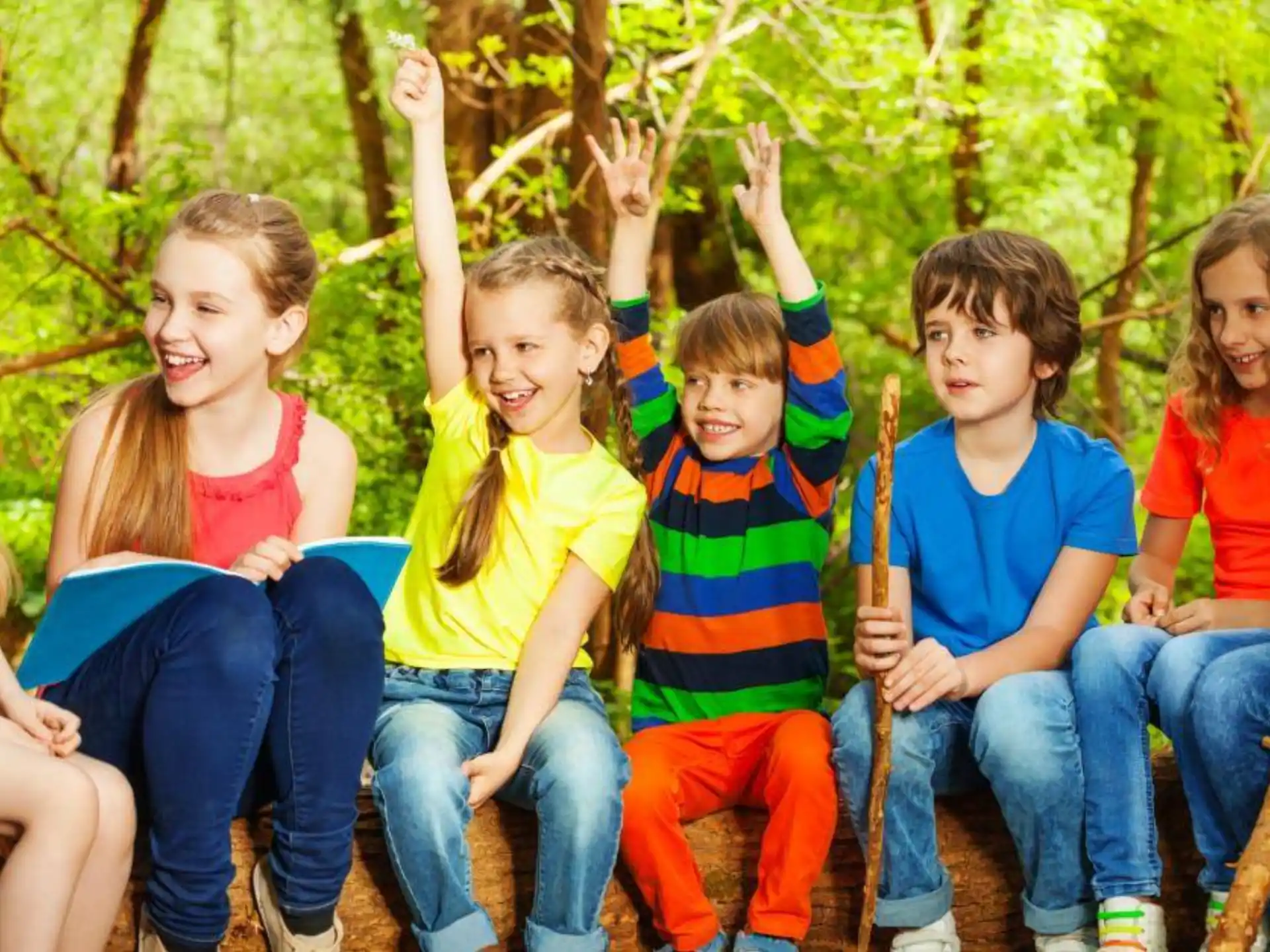 a group of children sitting on a log