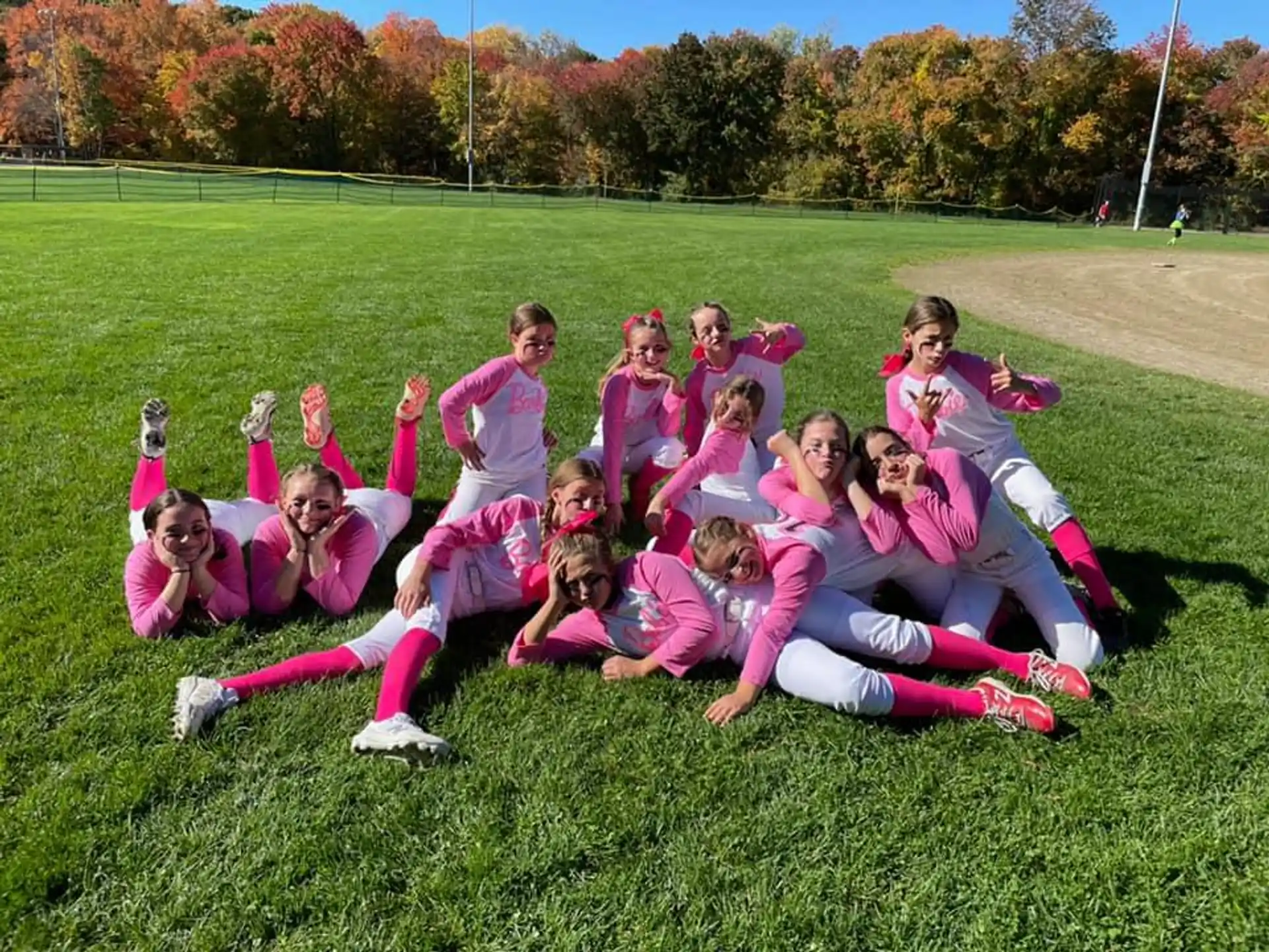 a group of girls in a huddle on a grass field