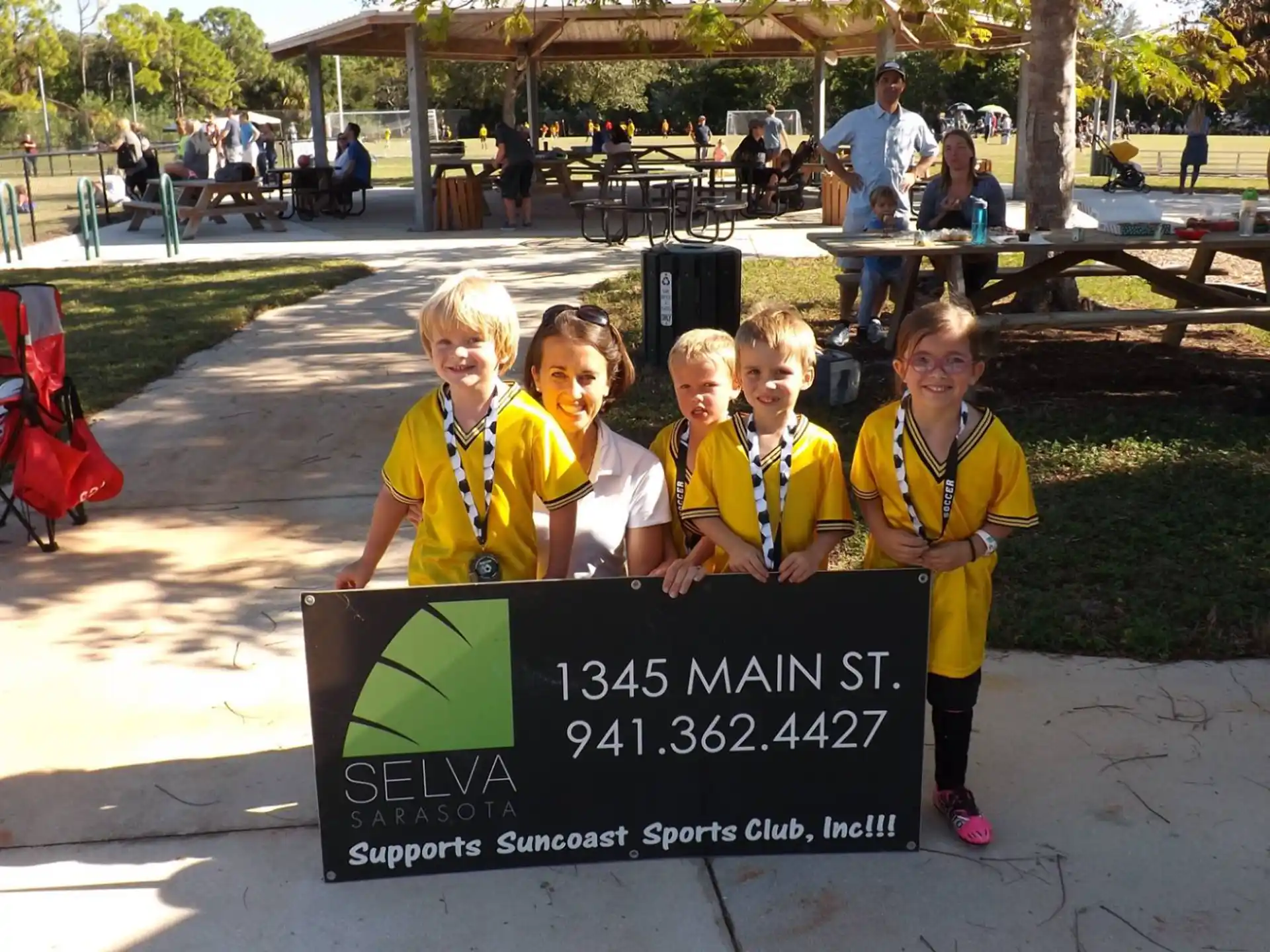 a group of girls posing for a picture with a sign