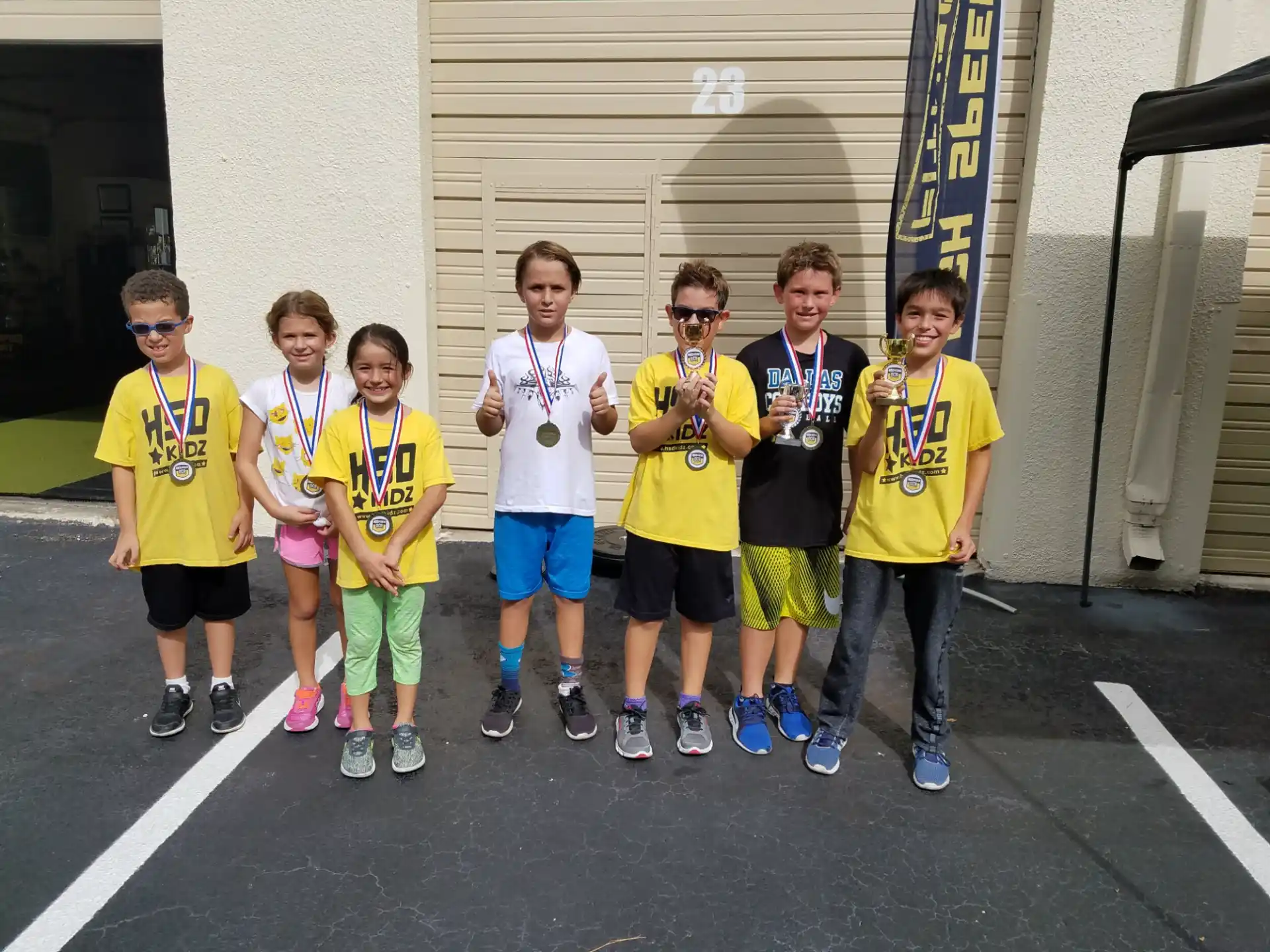 a group of kids wearing matching t-shirts and standing in a parking lot
