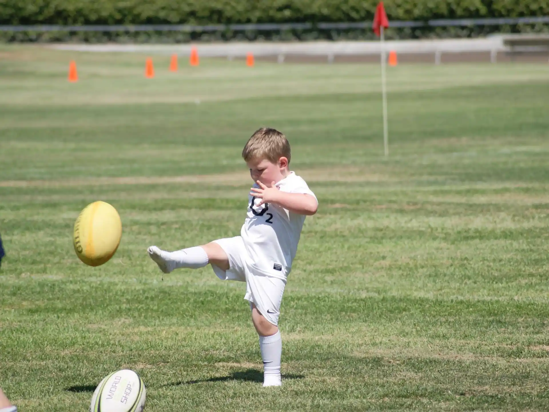 a boy kicking a football ball