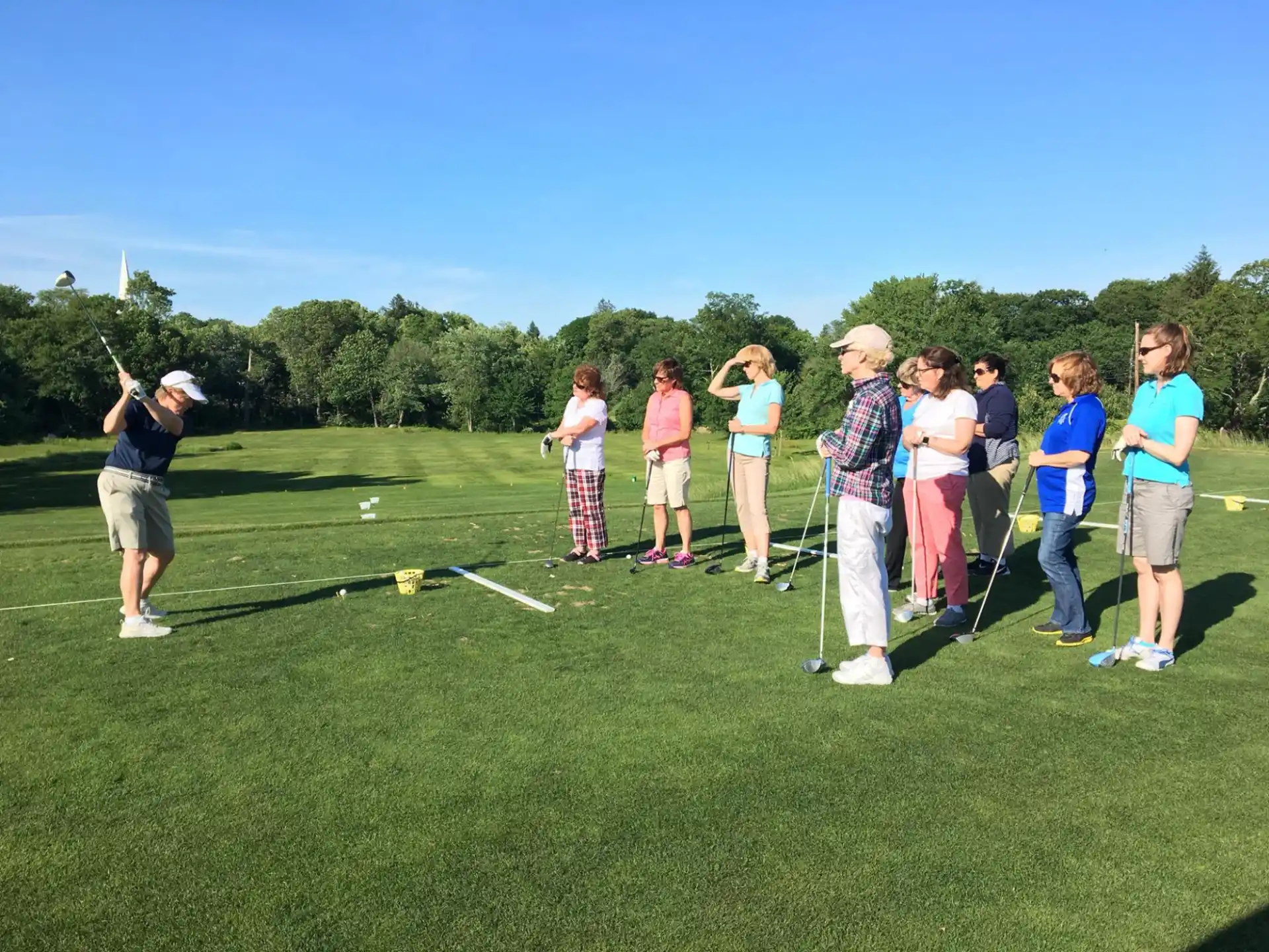 a group of people standing on a golf course