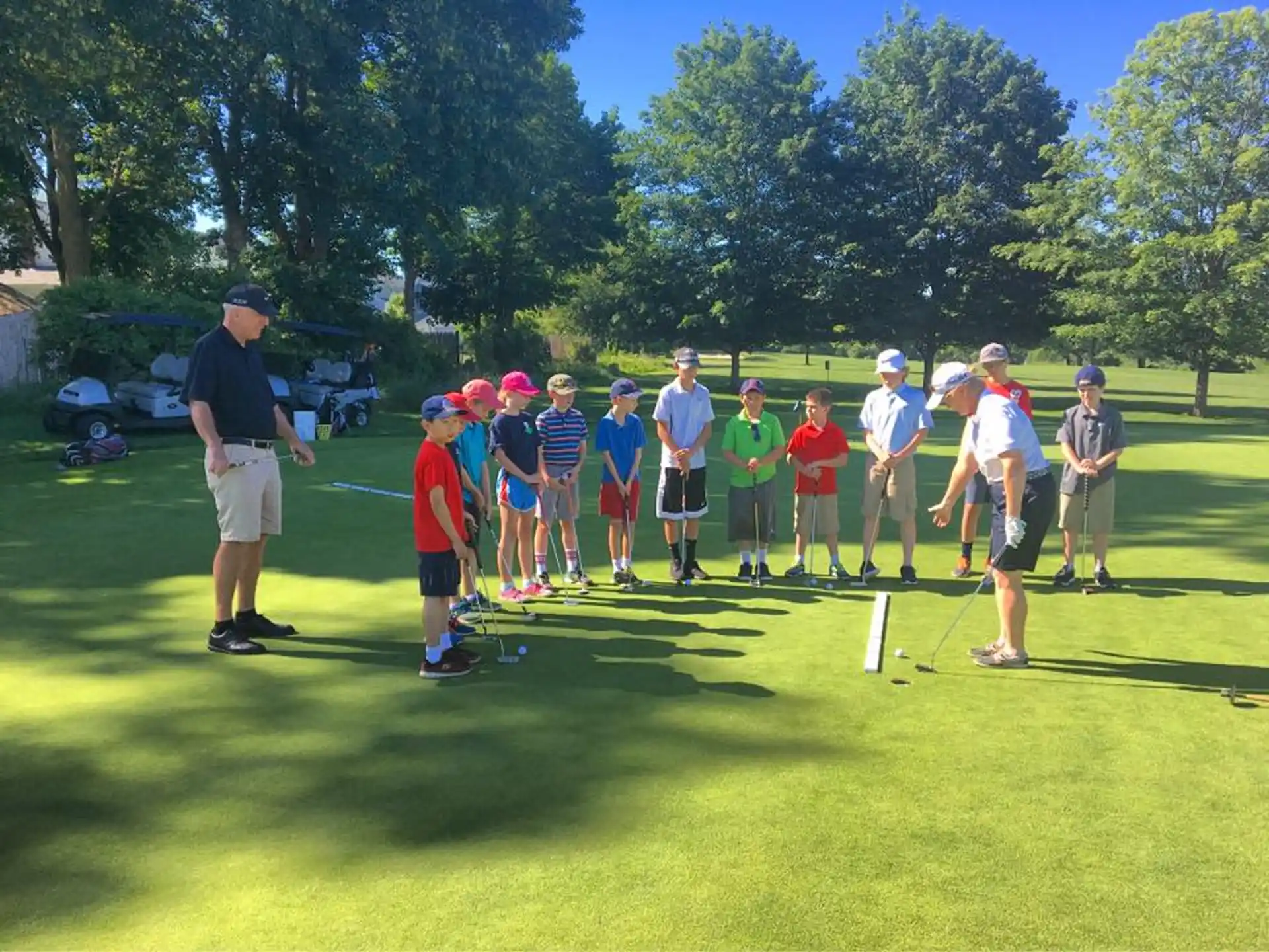 a group of people standing on a golf course