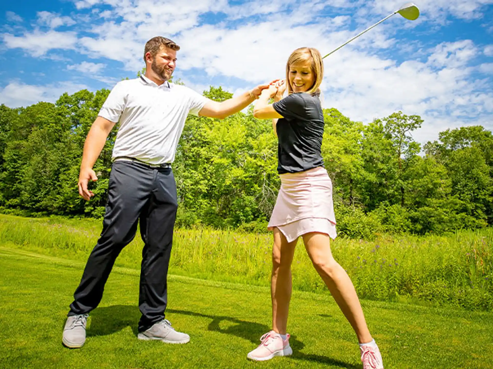 a man and a woman playing frisbee in a park