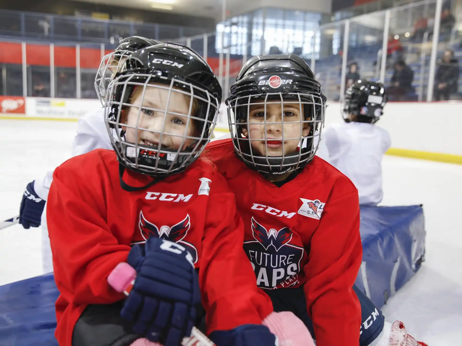 a couple of people wearing helmets and holding hockey sticks