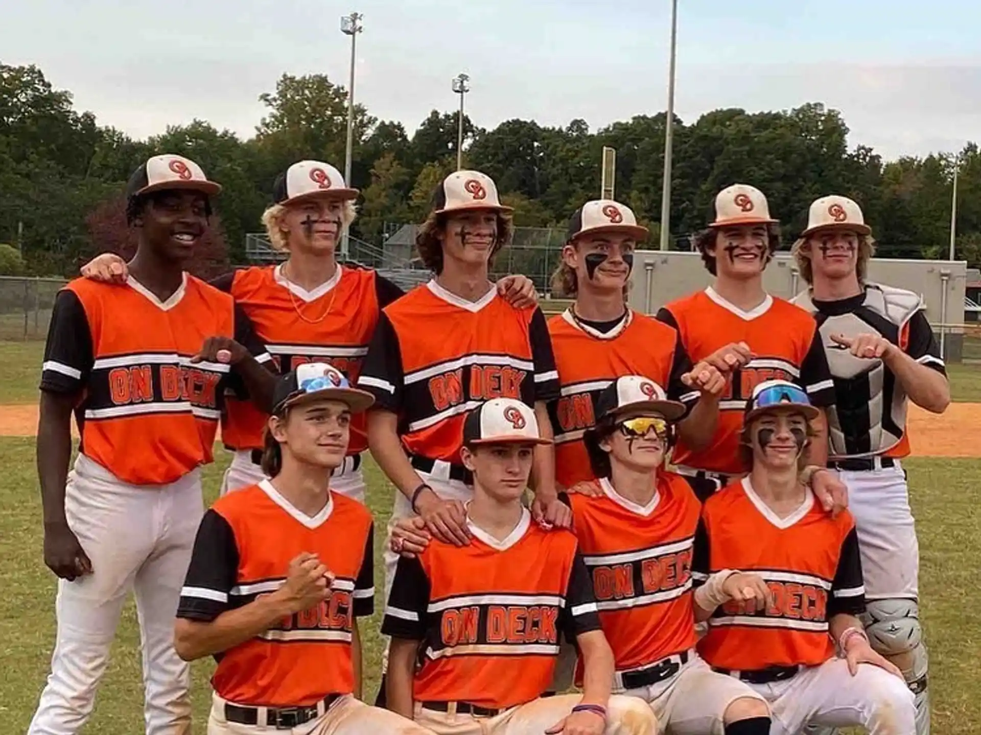 a group of people wearing orange vests and hats posing for a photo