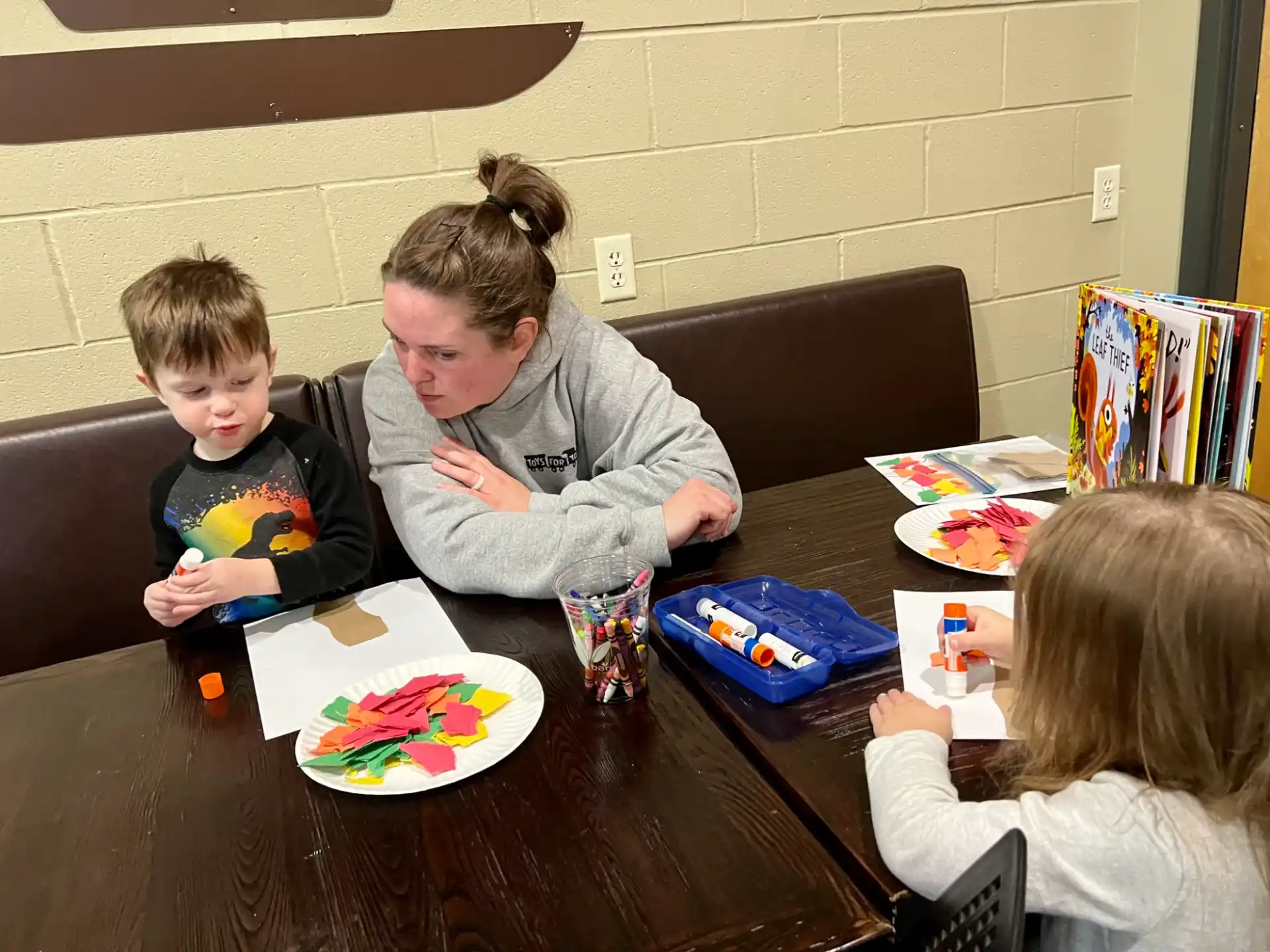 a group of children sitting around a table eating food