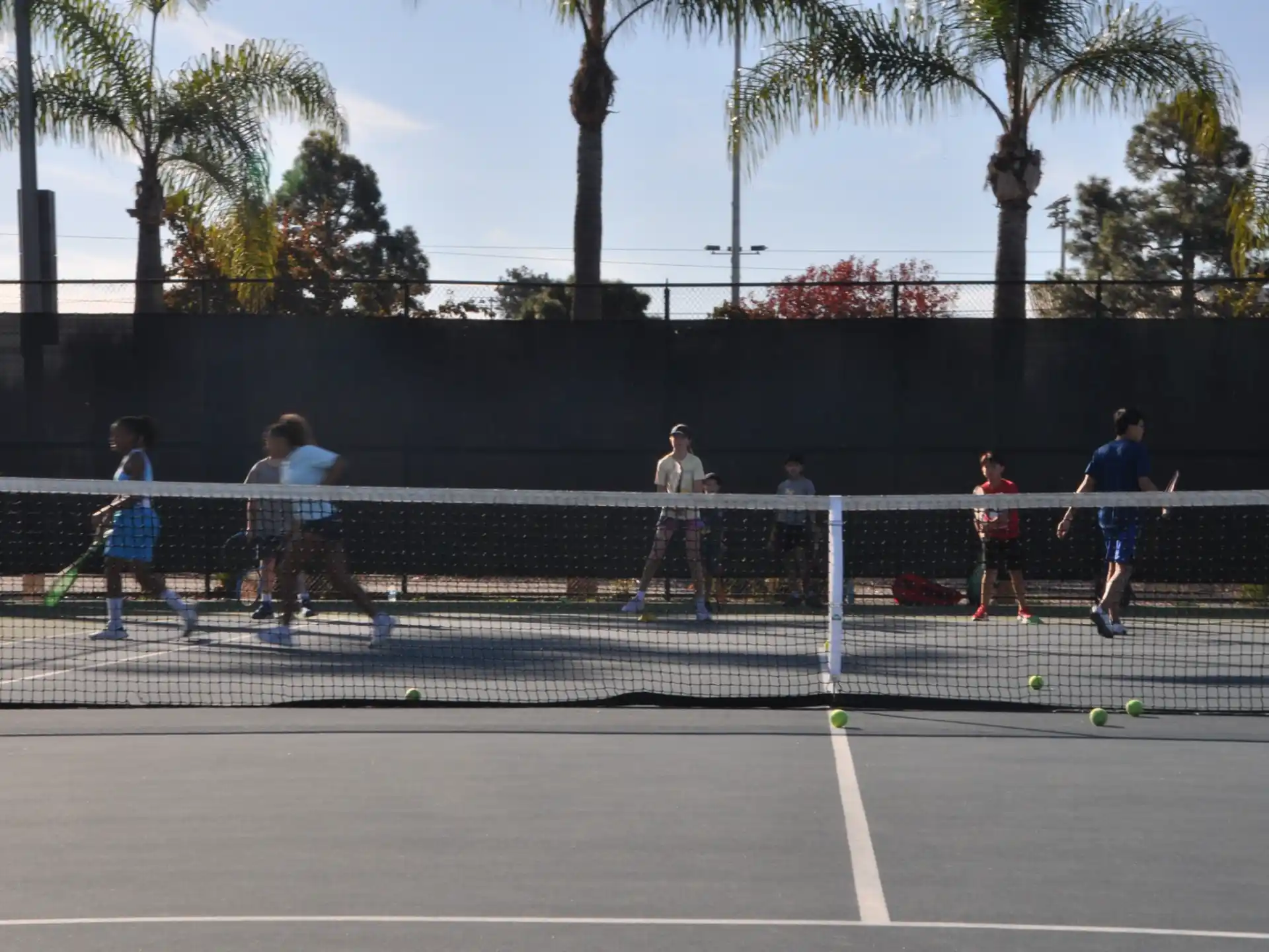a group of people play tennis