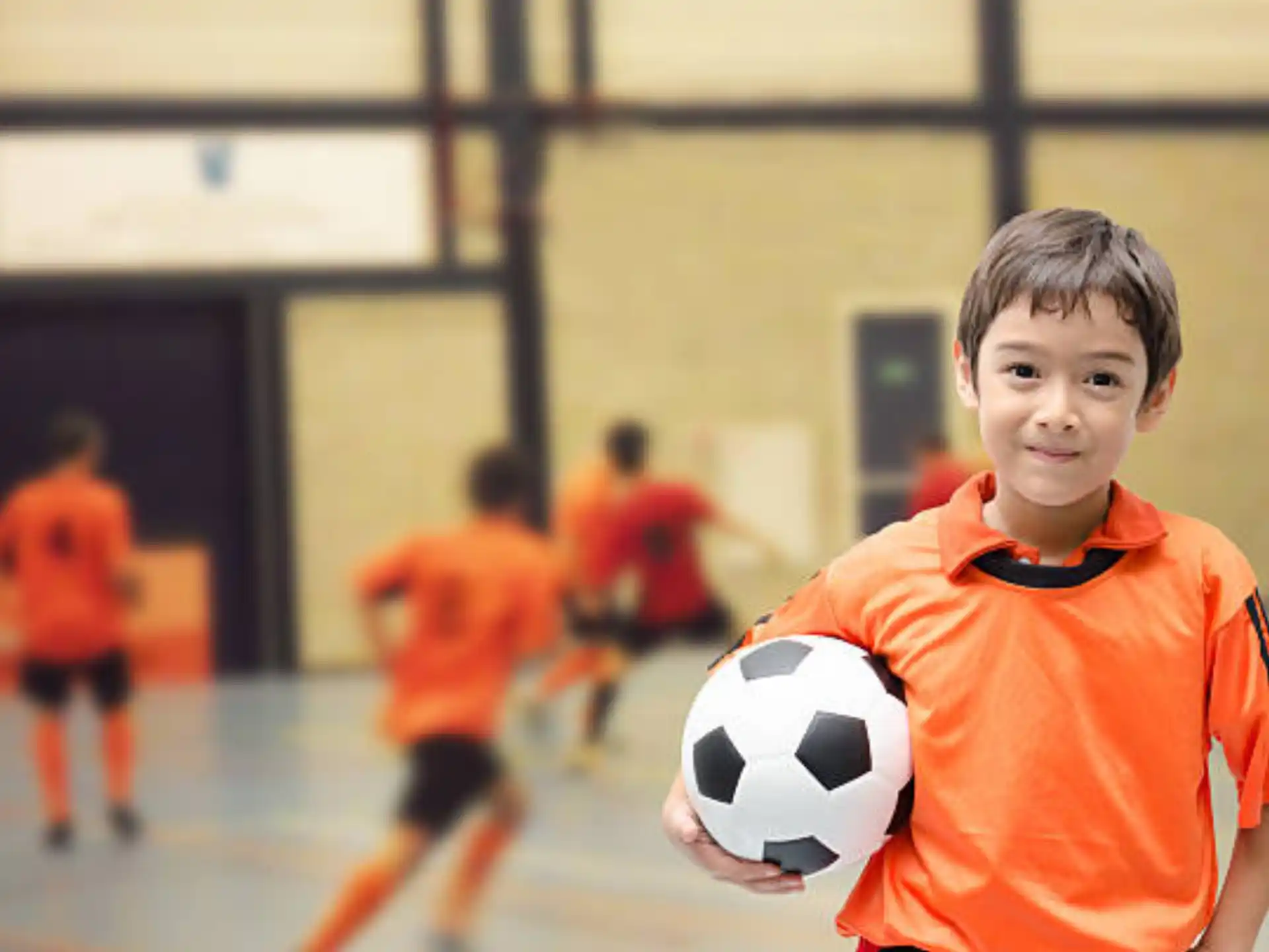 a boy holding a football ball