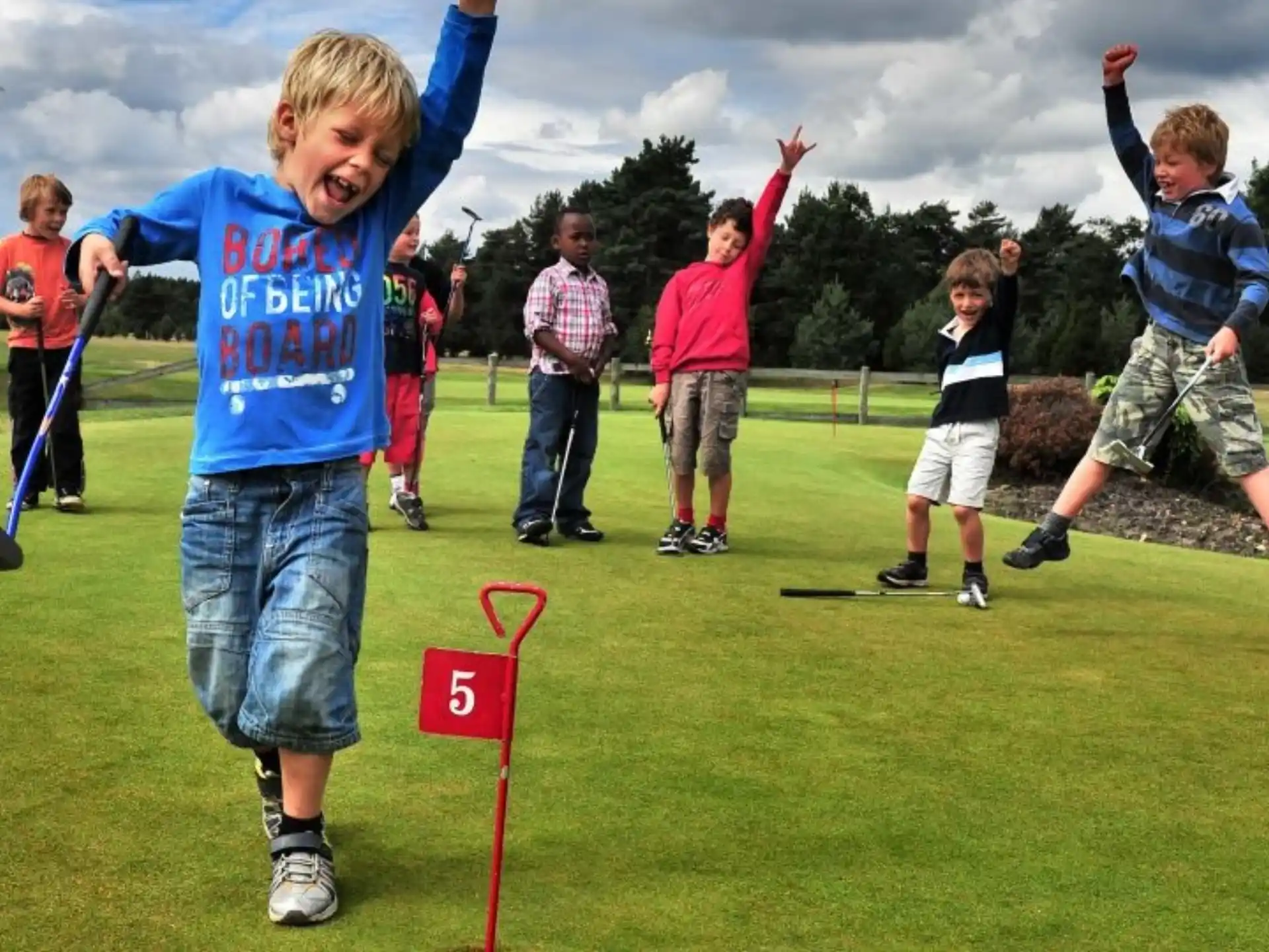 a group of kids playing golf