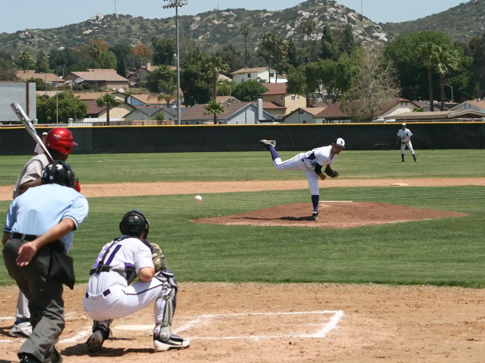 a pitcher throwing a baseball to a batter at a baseball game