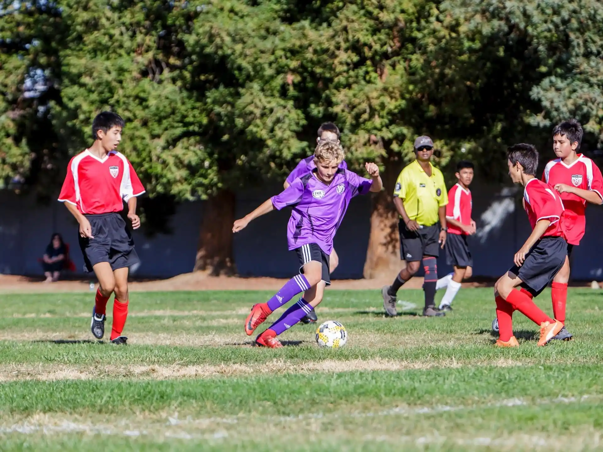 a group of kids compete over a football ball