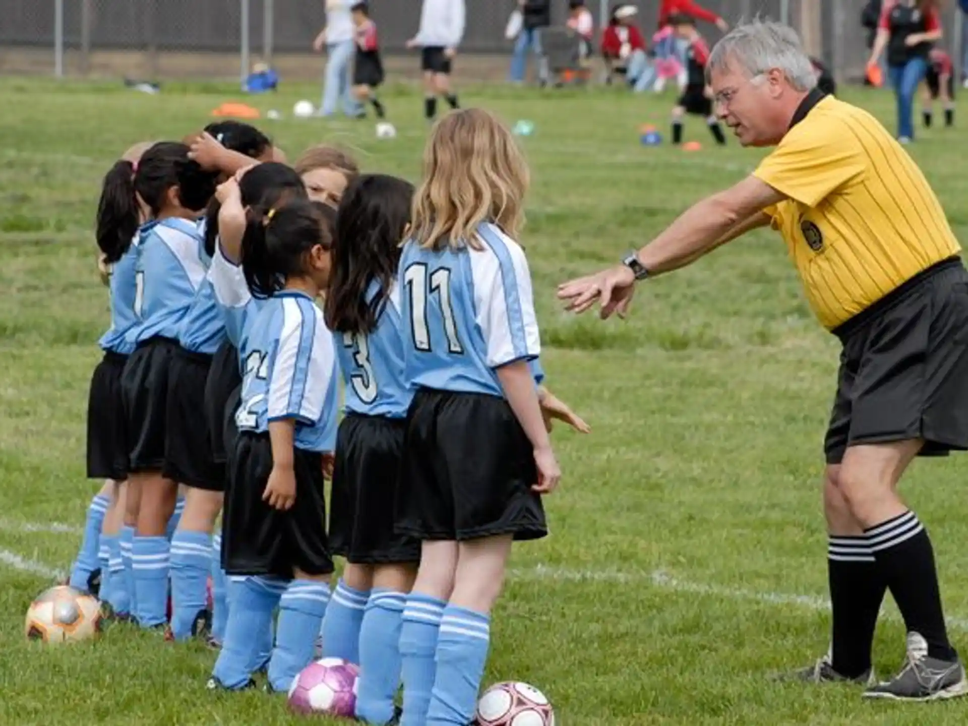 a person and a group of kids playing football