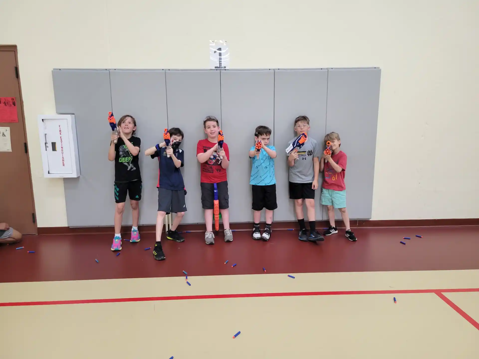 a group of kids standing on a mat in front of a chalkboard