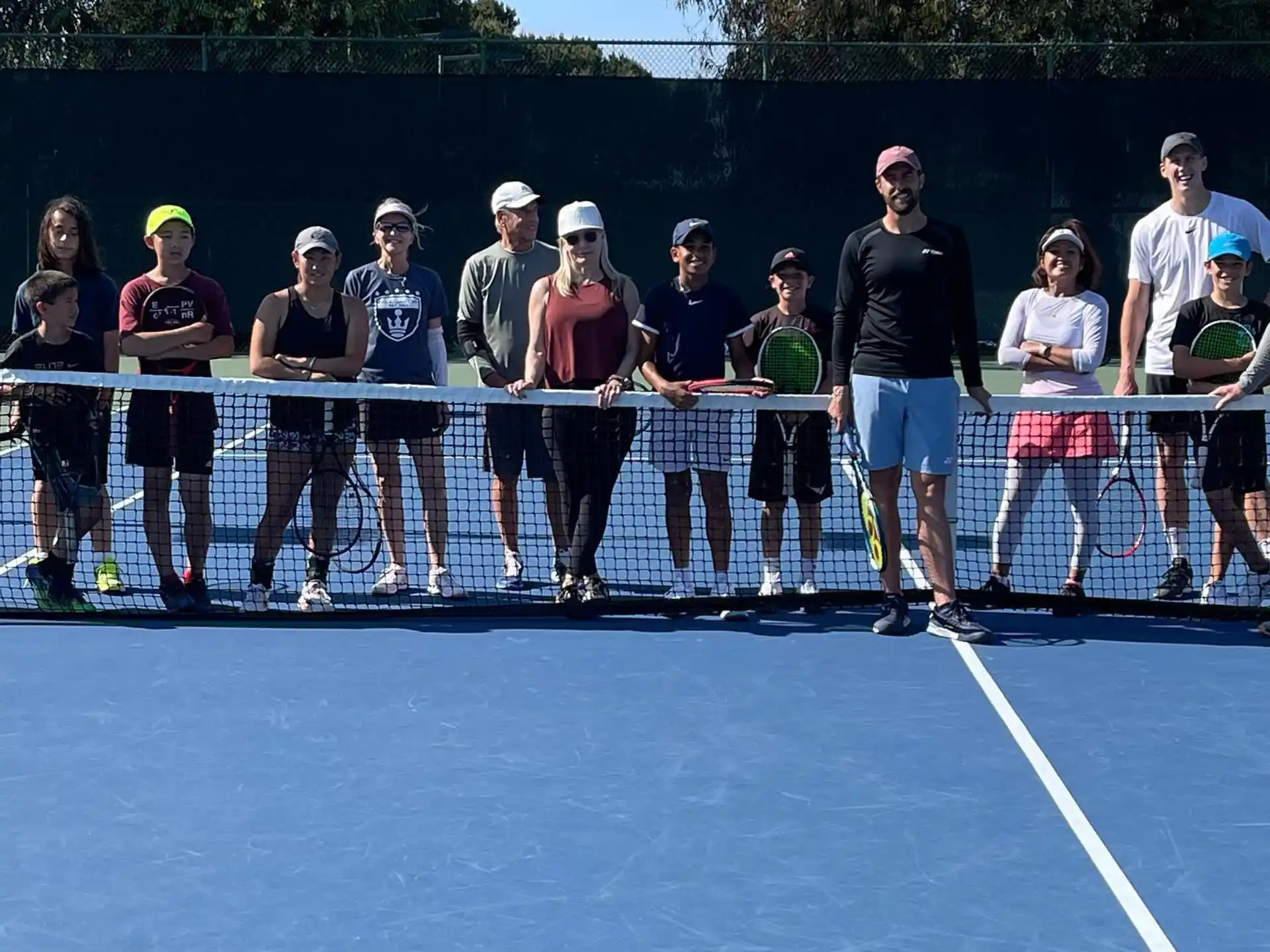 a group of people standing on a tennis court