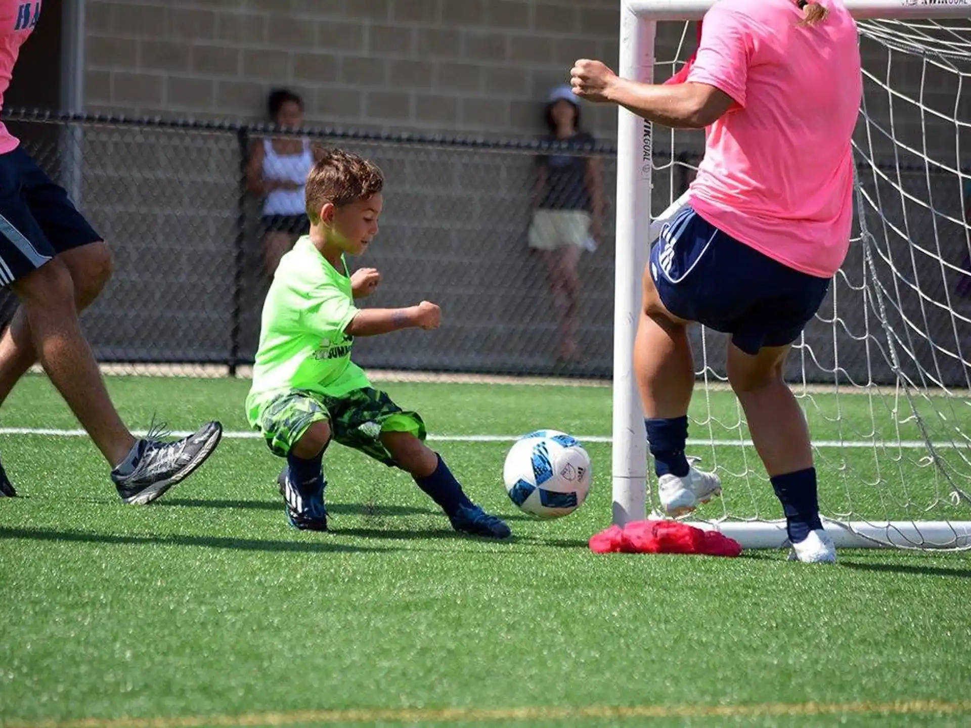 a kid kicks a football ball