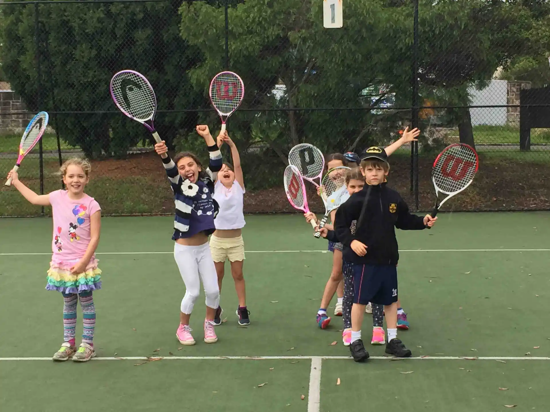 kids holding tennis rackets