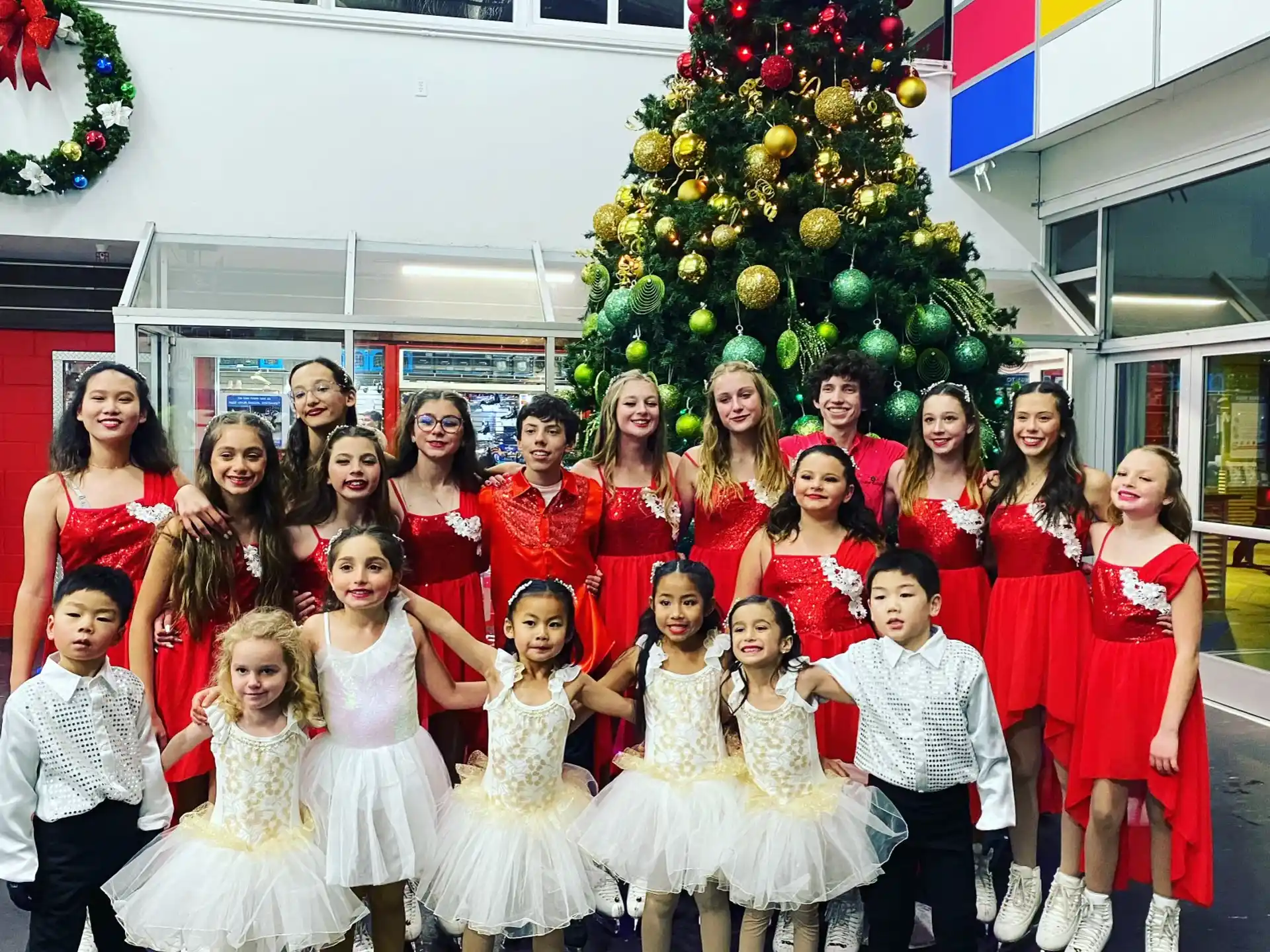 a group of people posing for a photo in front of a christmas tree