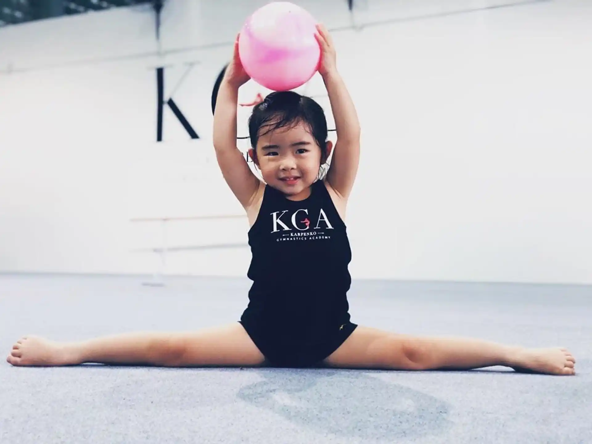 a girl holding a pink ball