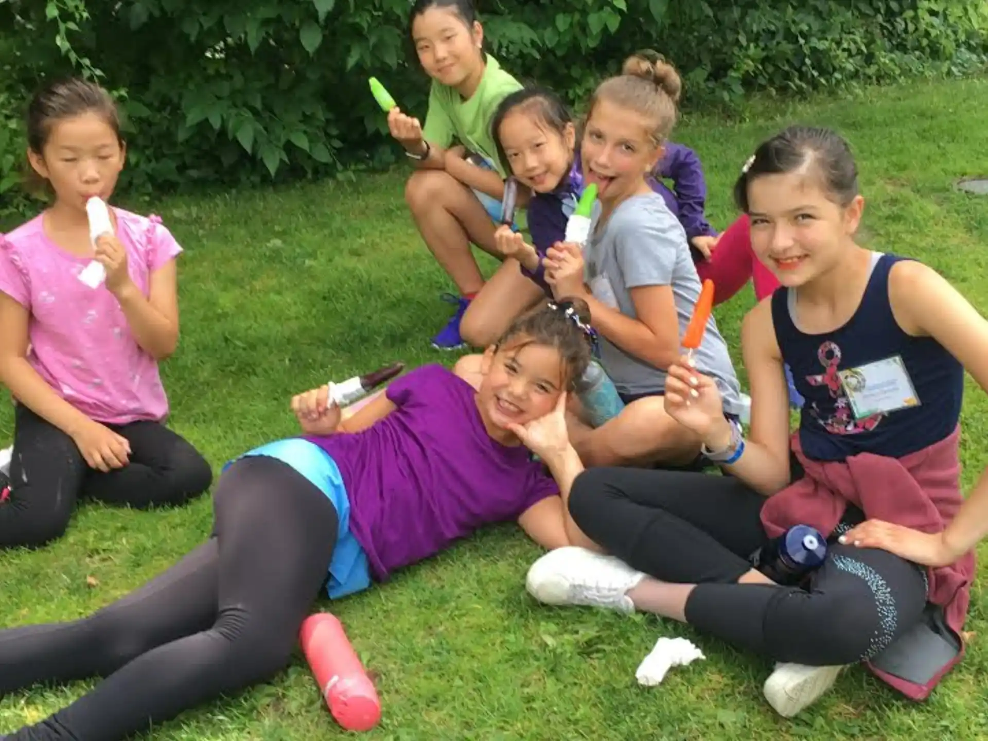 a group of girls sitting on the grass