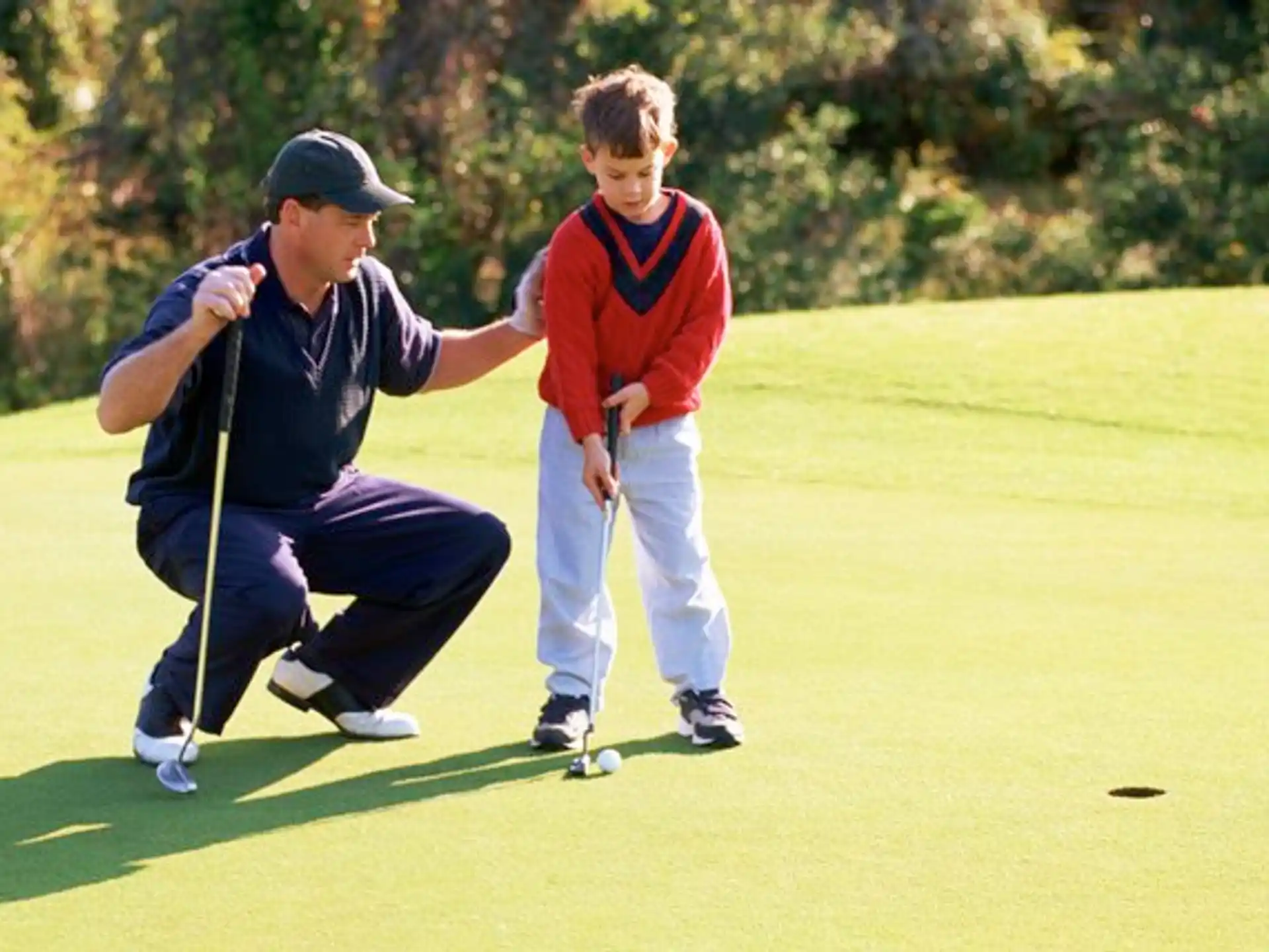 a person and a boy playing golf