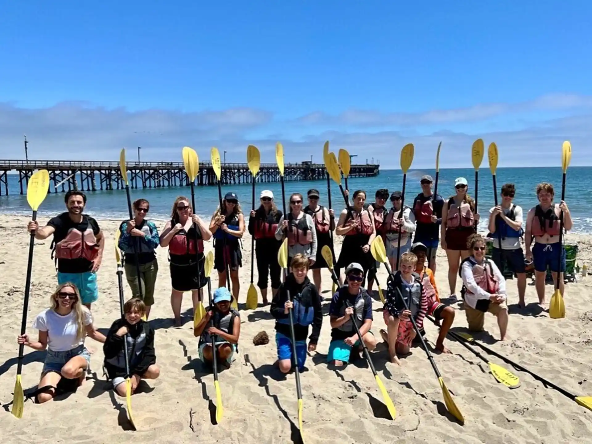 a group of people posing for a photo on a beach