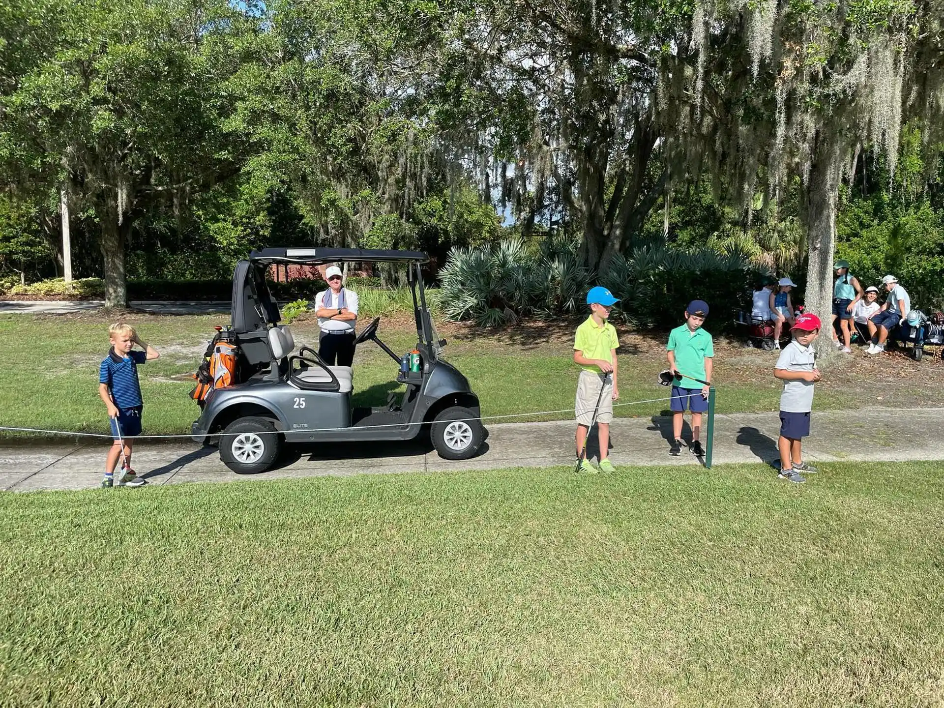 a group of people standing around a golf cart