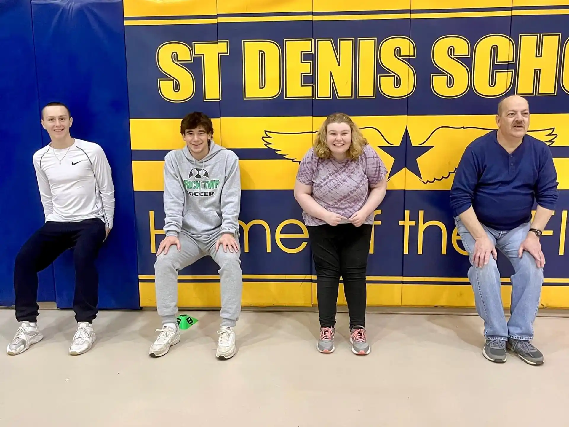 a group of people sitting on a bench in front of a sign
