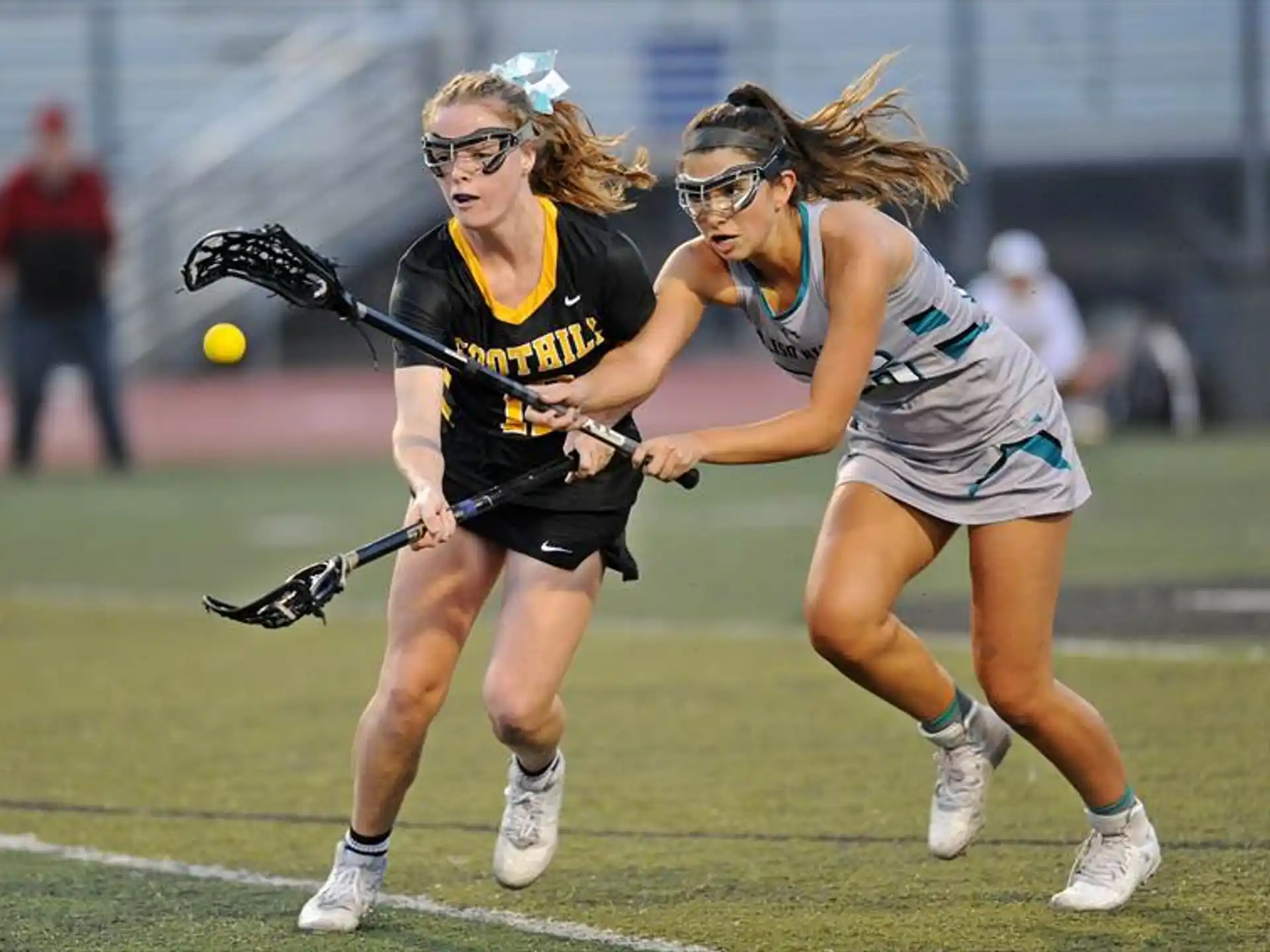women playing lacrosse on a field
