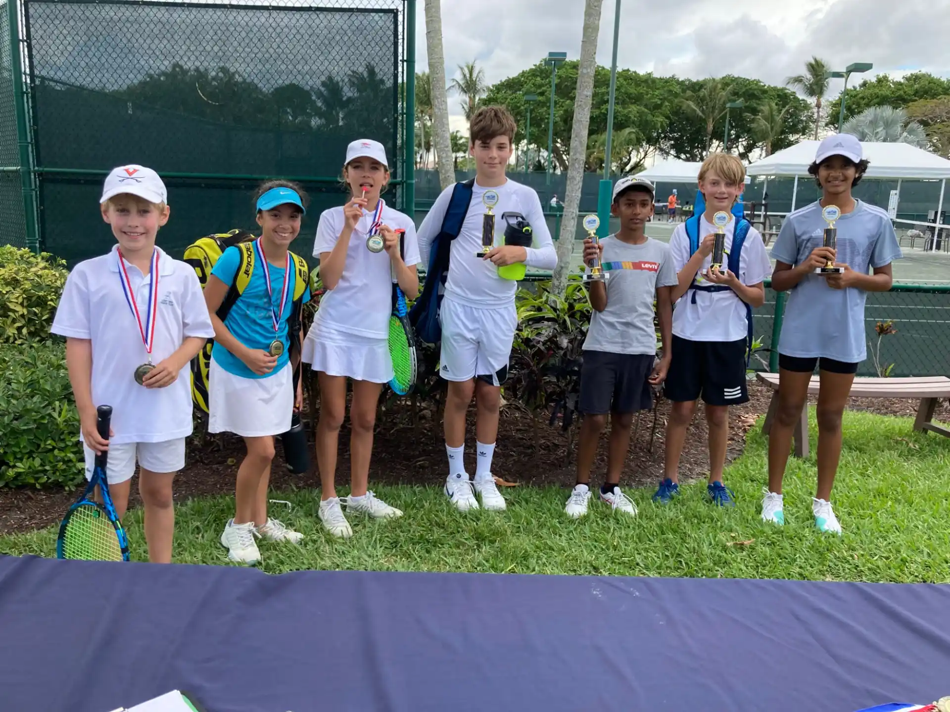 a group of kids holding tennis rackets