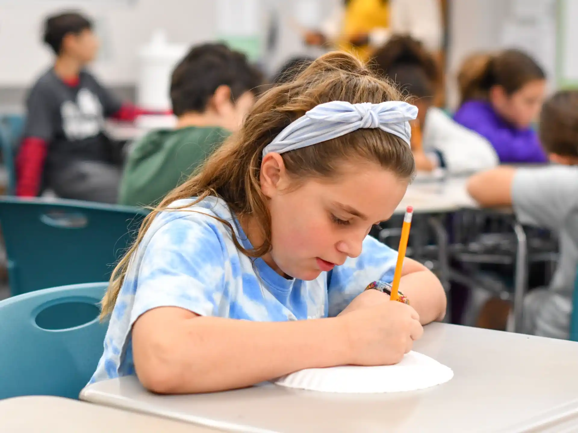 a young girl writing on a piece of paper