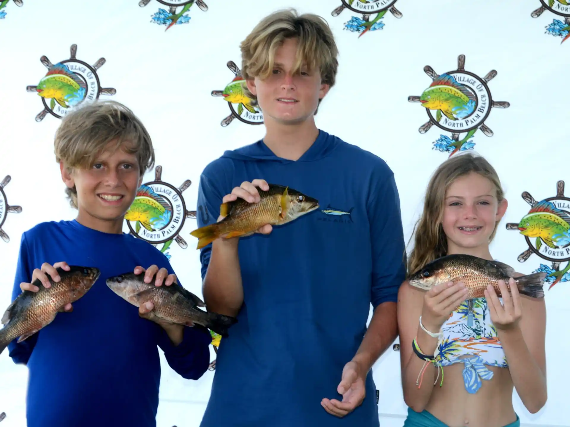 a group of people holding fish