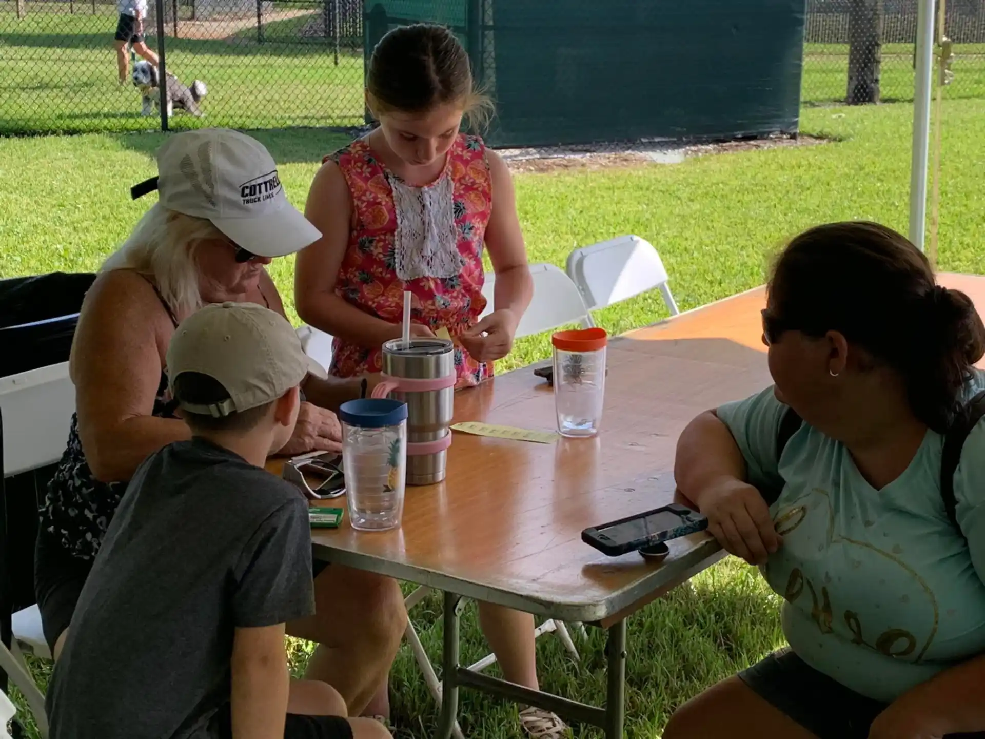 a group of people sitting around a table outside
