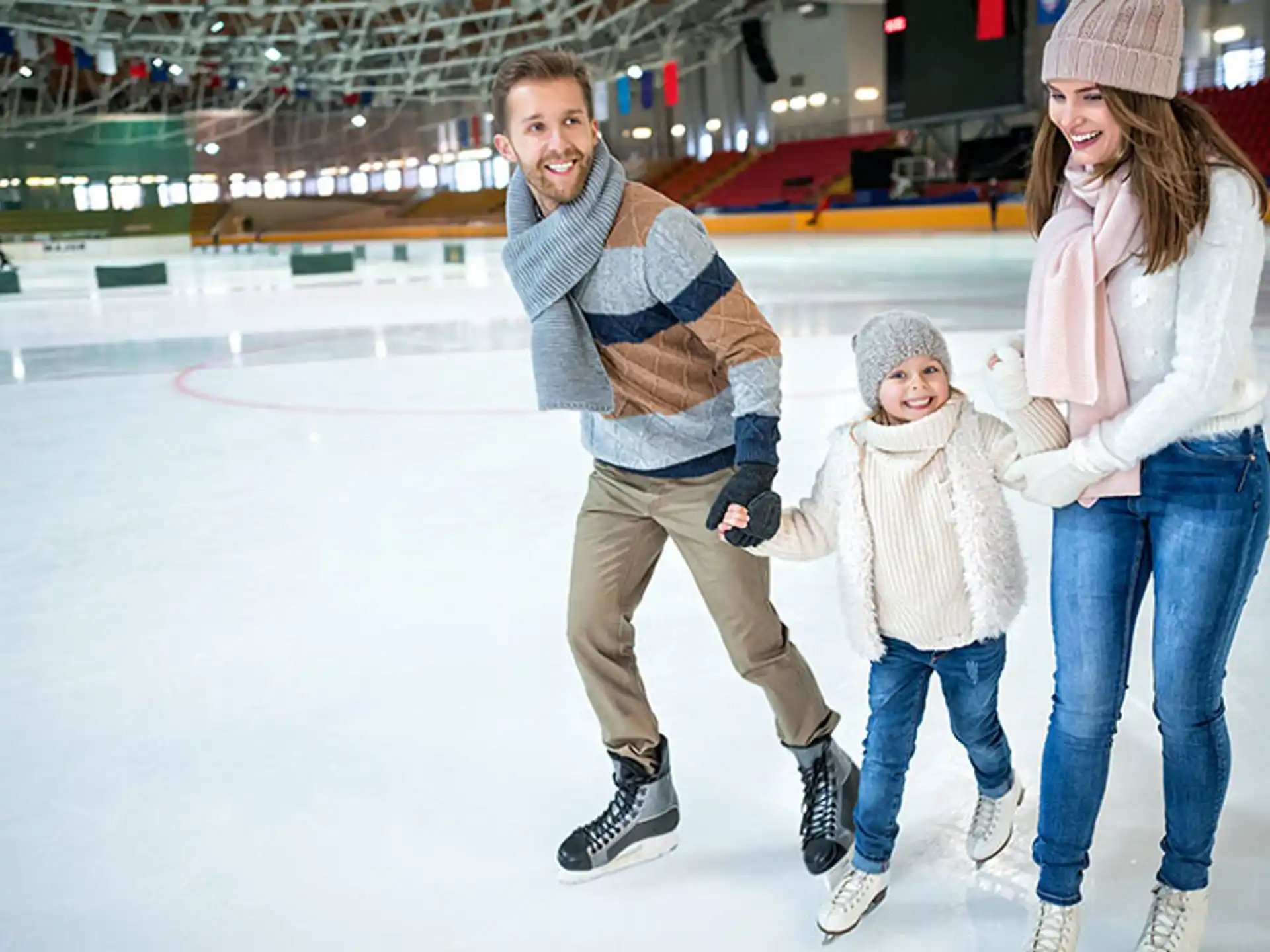 a man and woman with a child on an ice rink
