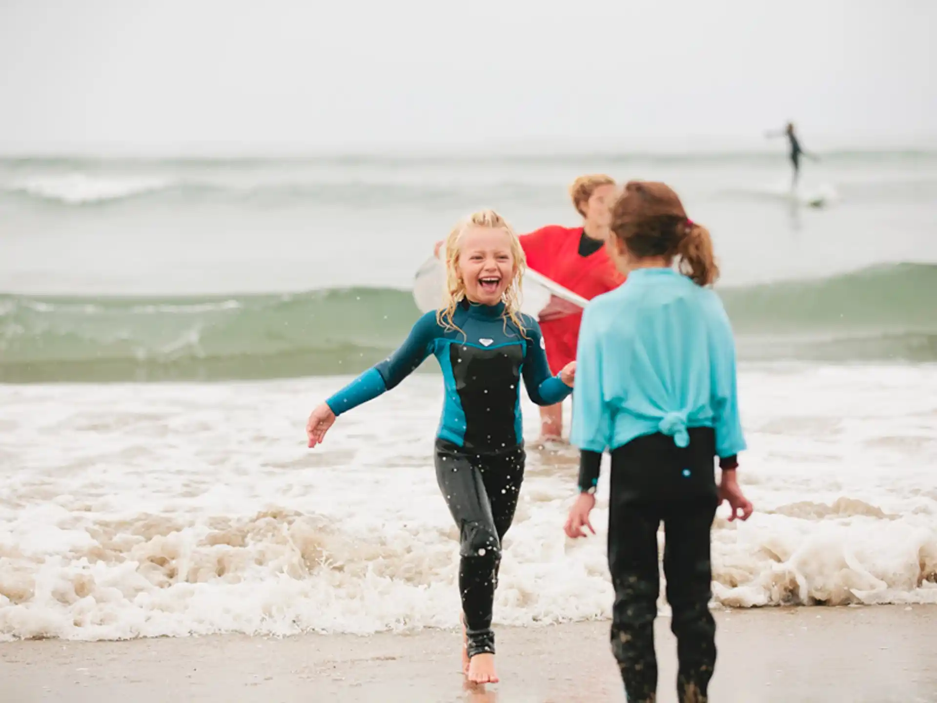 a group of people running on a beach