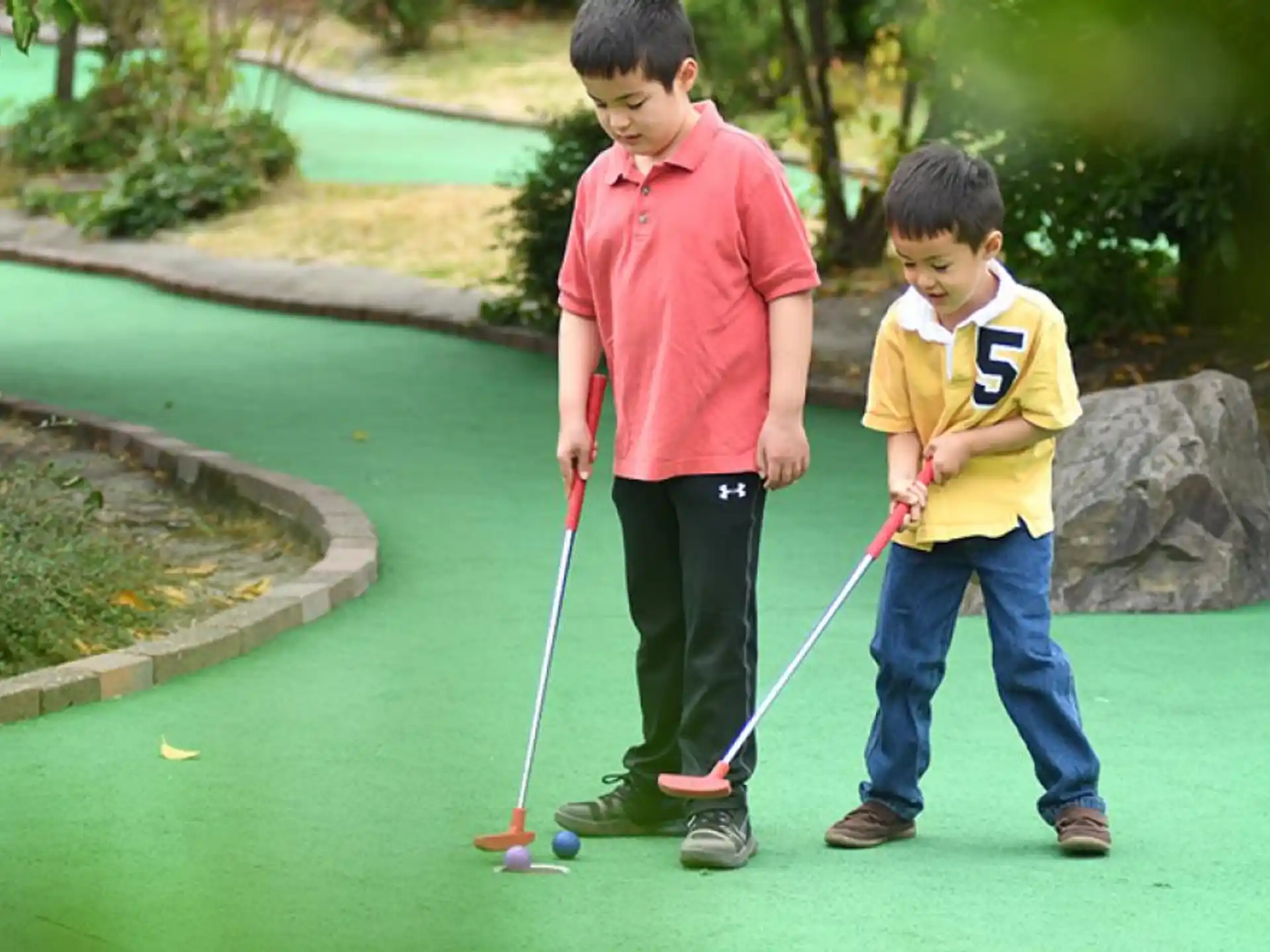 two boys holding golf clubs